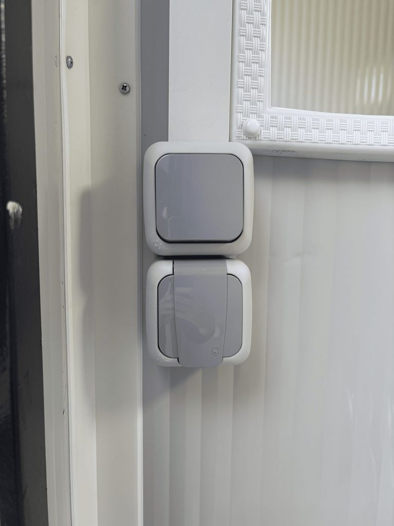 Close-up van aansluiting voor elektriciteit en lichtschakelaar in een mobiele toilet unit