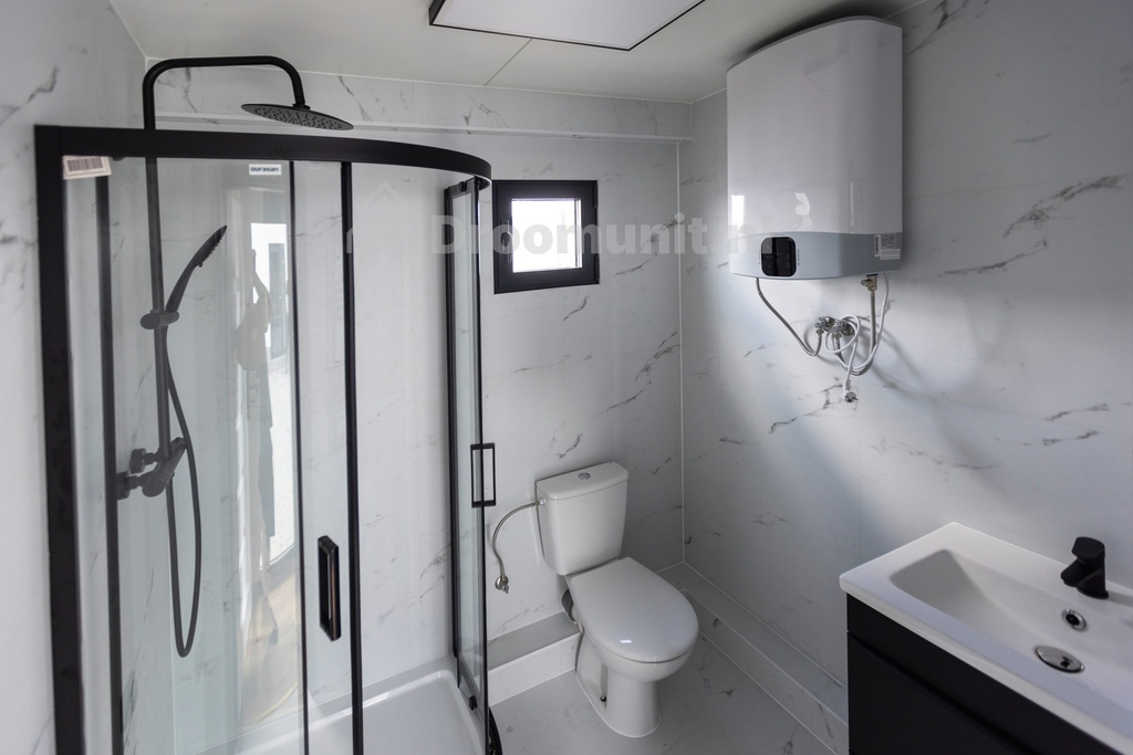 Badkamer met toilet, douchecabine, wastafel en boiler in luxe mobiele prefab woonunit Emmy met 1 slaapkamer, afmeting 1100x300