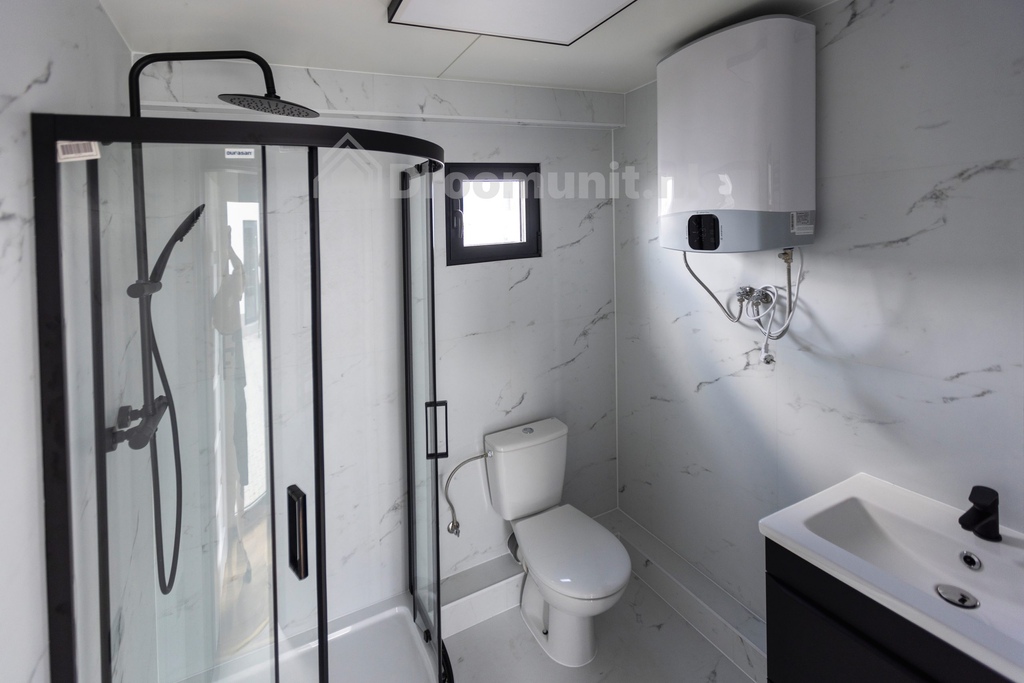 Badkamer met toilet, douchecabine, wastafel en boiler in luxe mobiele prefab woonunit Emmy met 1 slaapkamer, afmeting 1300x300