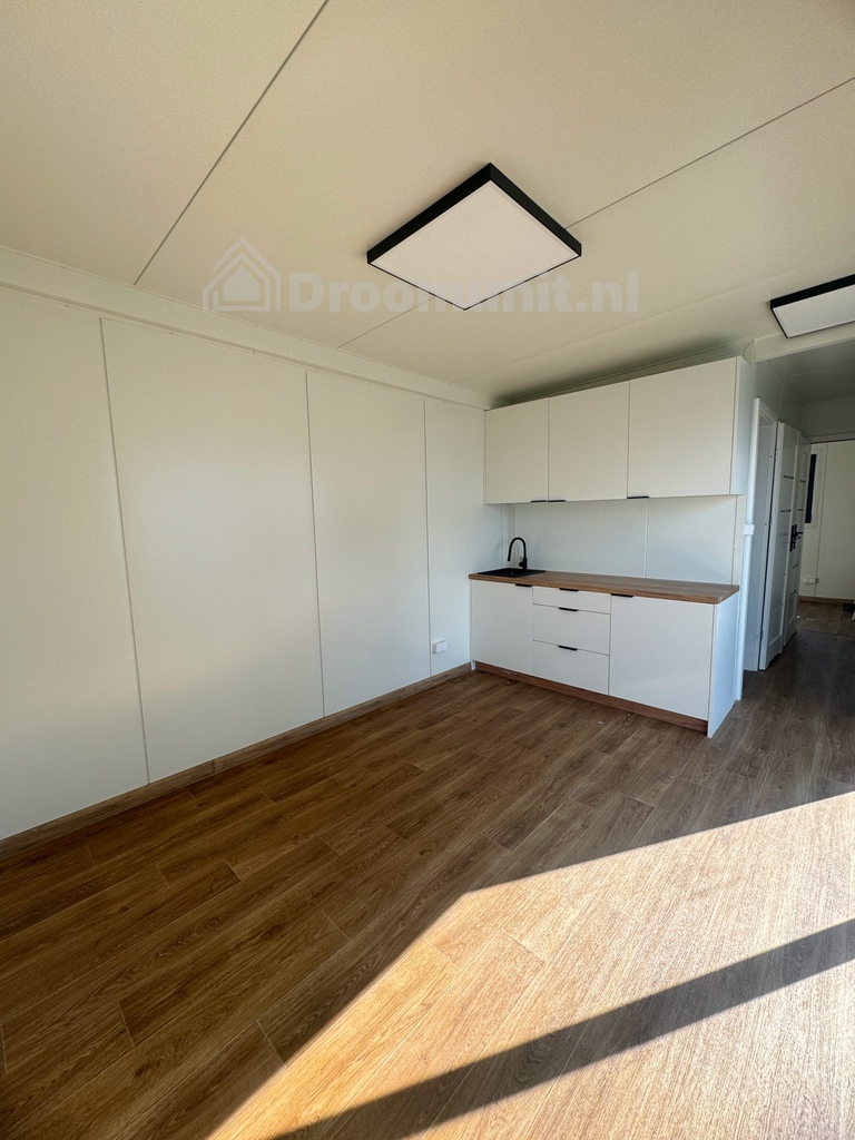 Leefruimte met keuken in luxe mobiele prefab woonunit Emmy met 1 slaapkamer, afmeting 1000x300