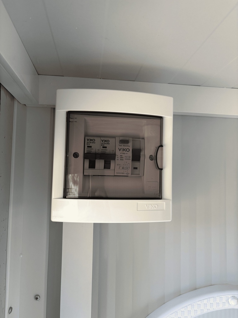 Close-up van 16A groepenkast aan de binnenzijde van een mobiele toilet unit