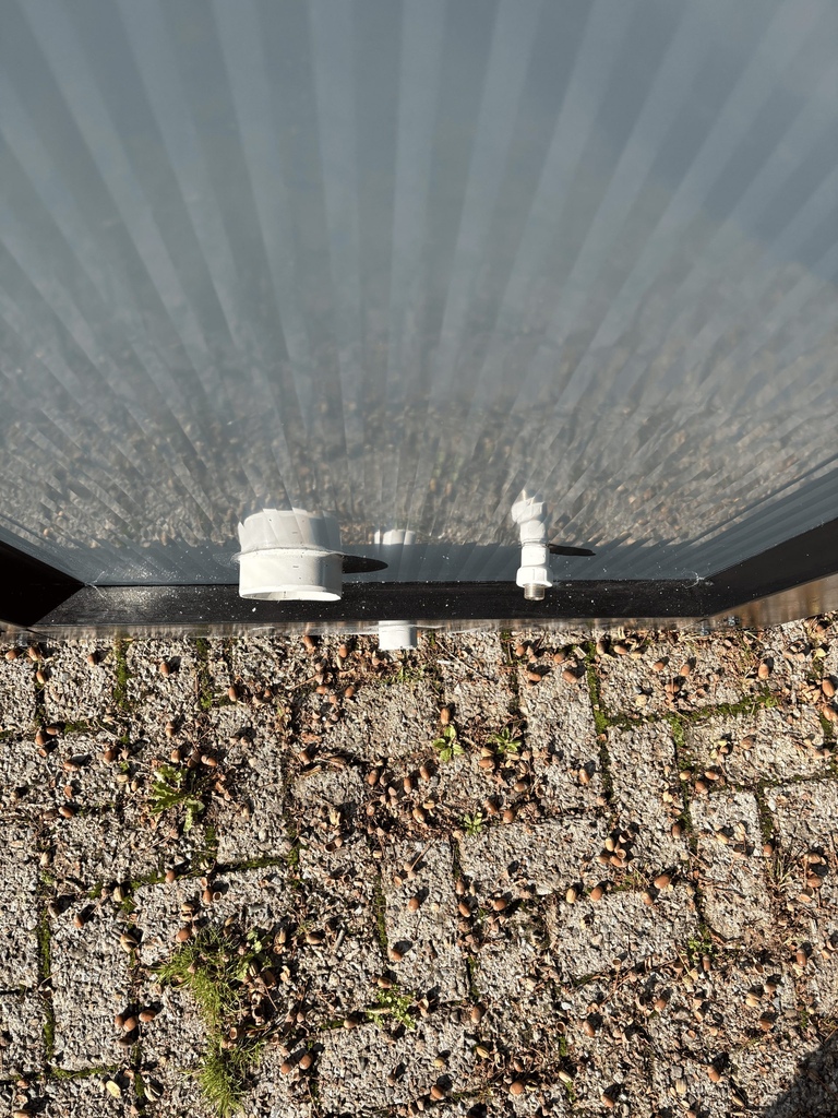 Bovenaanzicht van aansluitingen aan de buitenzijde van een mobiele toilet unit