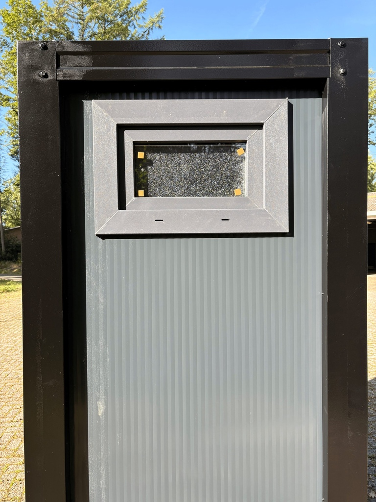 Kiepraam aan de buitenkant van een mobiele toilet unit