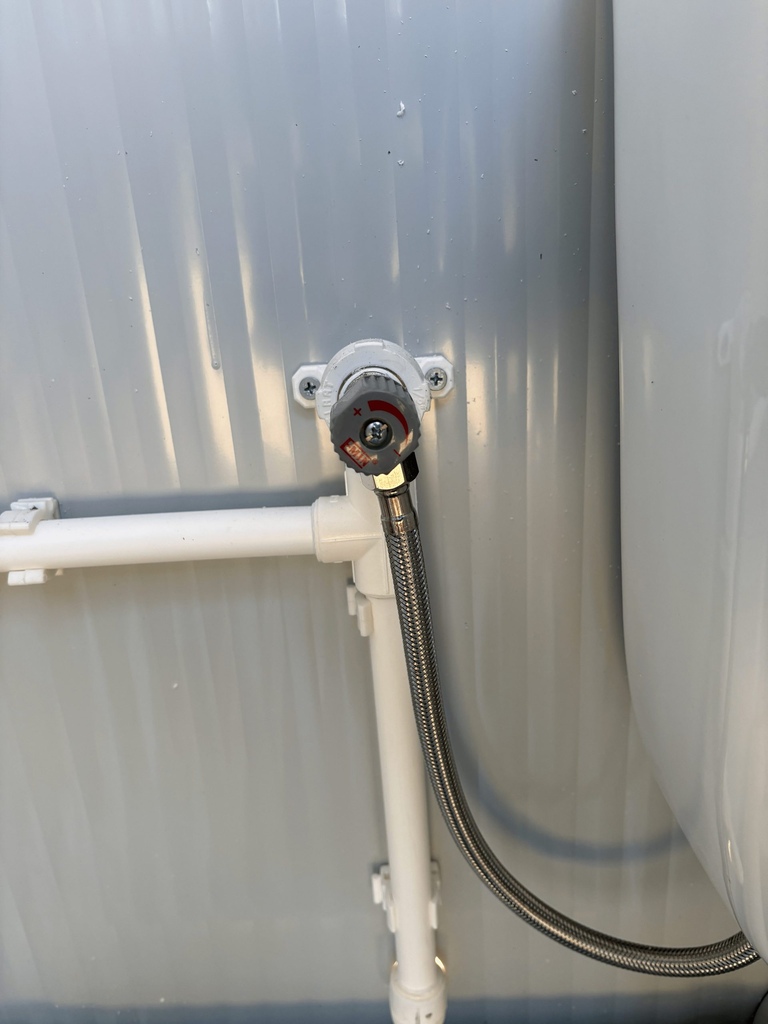 Close-up van leidingwerk met vorstbeveiliging in een mobiele toilet unit