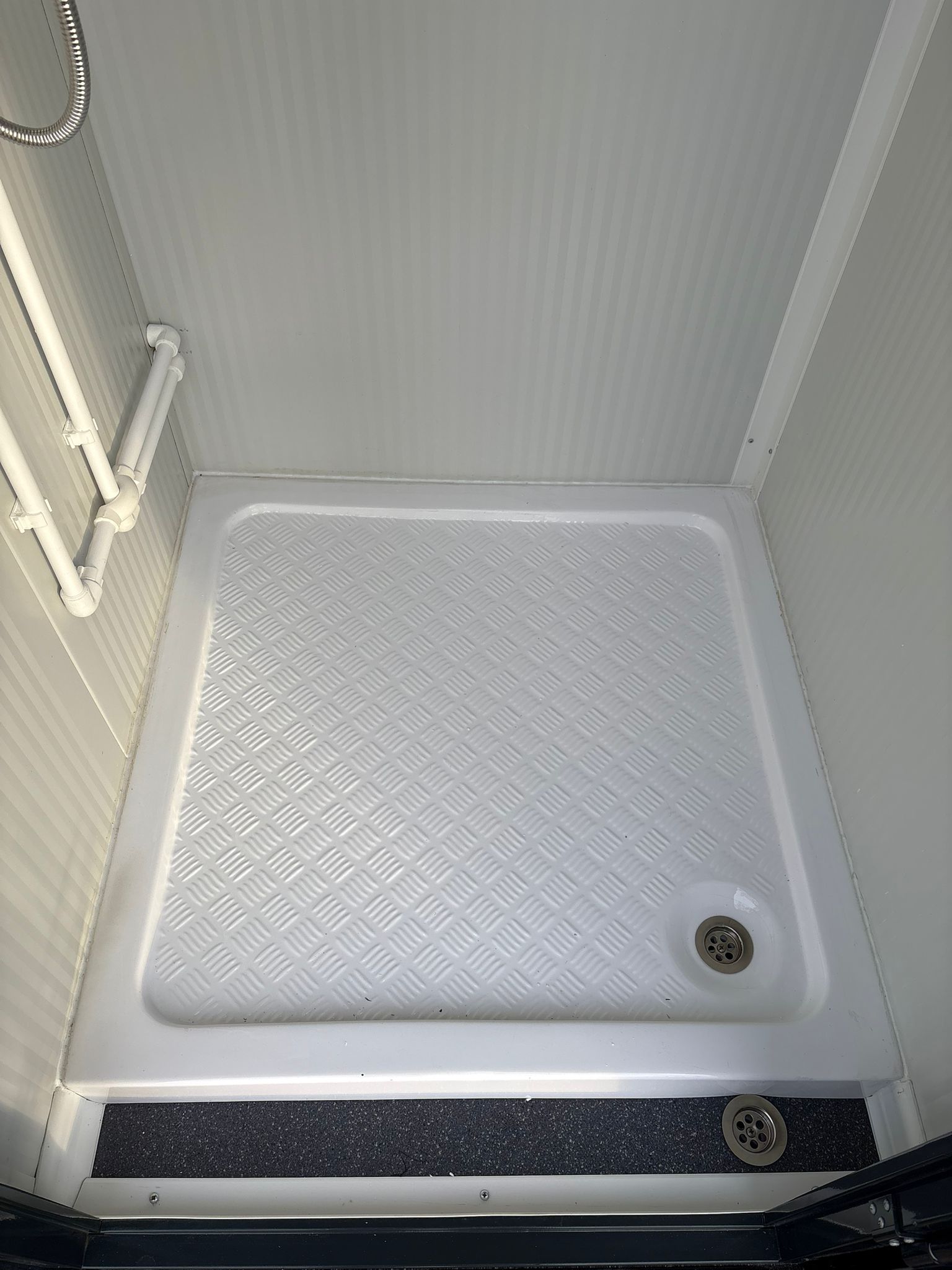 Douchebak van een toilet- en doucheunit.