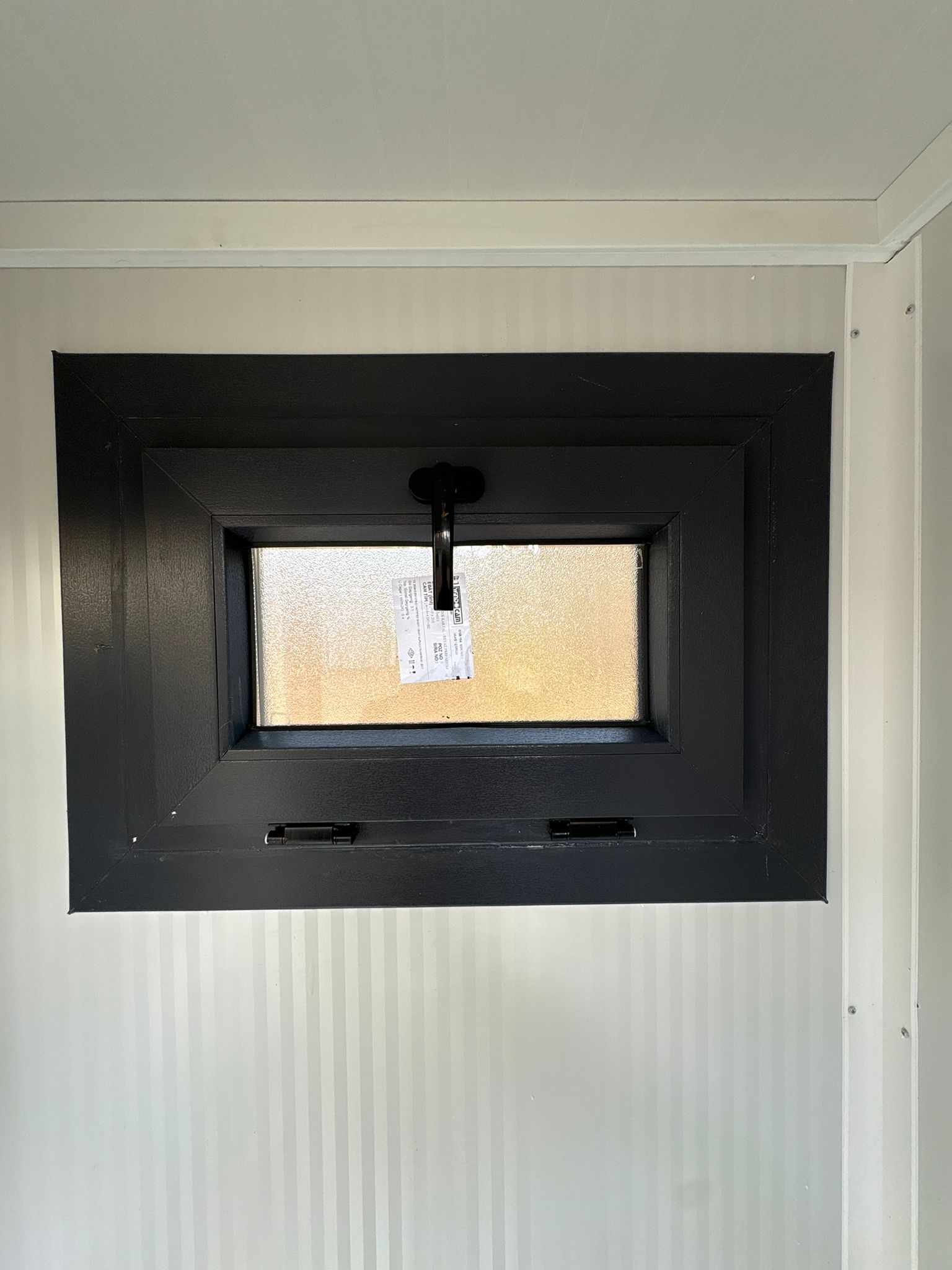 Dicht draaikiepraam in de doucheruimte van een toilet- en doucheunit.