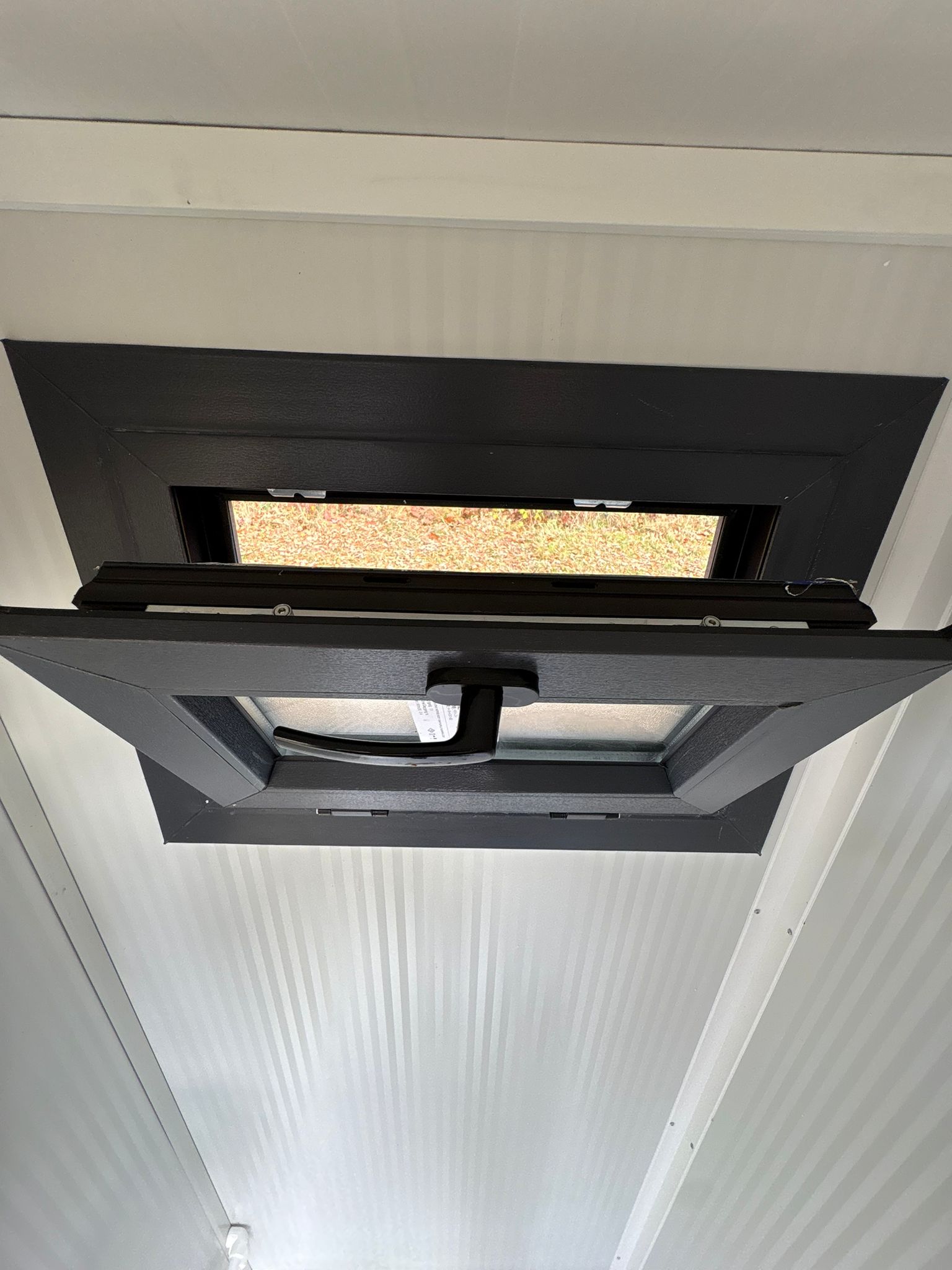 Openstaand draaikiepraam in de doucheruimte van een toilet- en doucheunit.