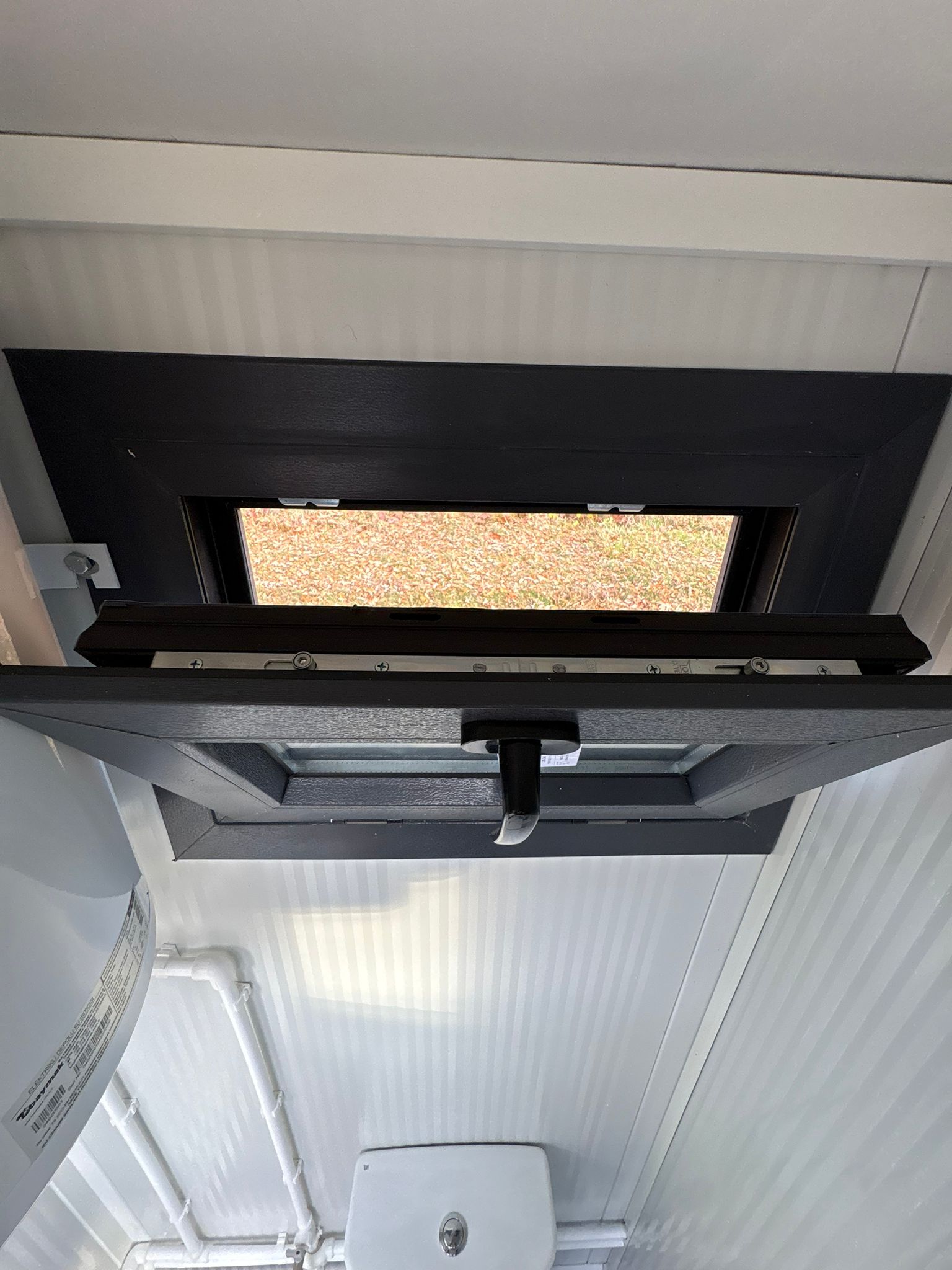 Openstaand draaikiepraam van een toilet- en doucheunit.