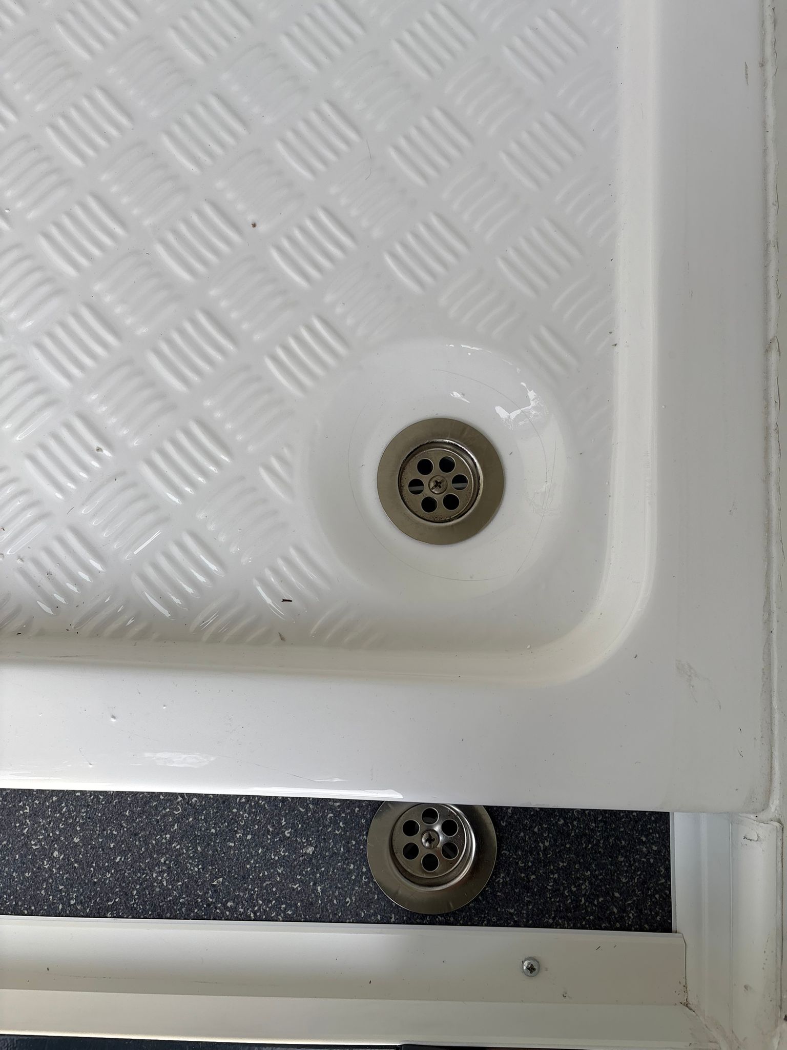 Vloerput in de toiletruimte van een toilet- en doucheunit.