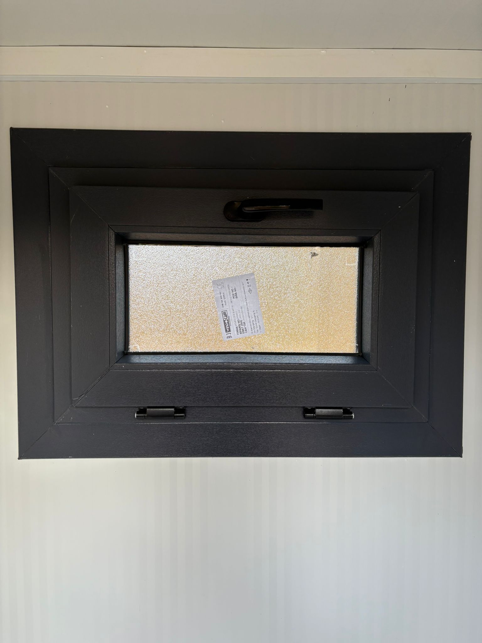 Dicht draaikiepraam aan de rechterzijde van een dubbele toilet unit.