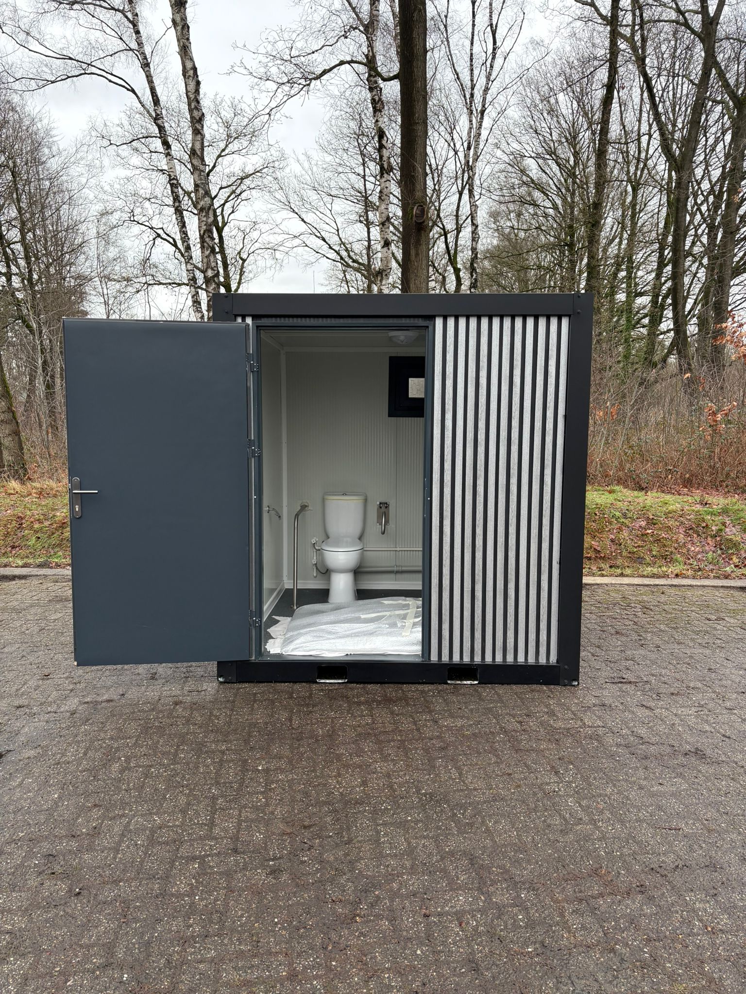 Vooraanzicht van mobiele MIVA toiletunit met geopende deur