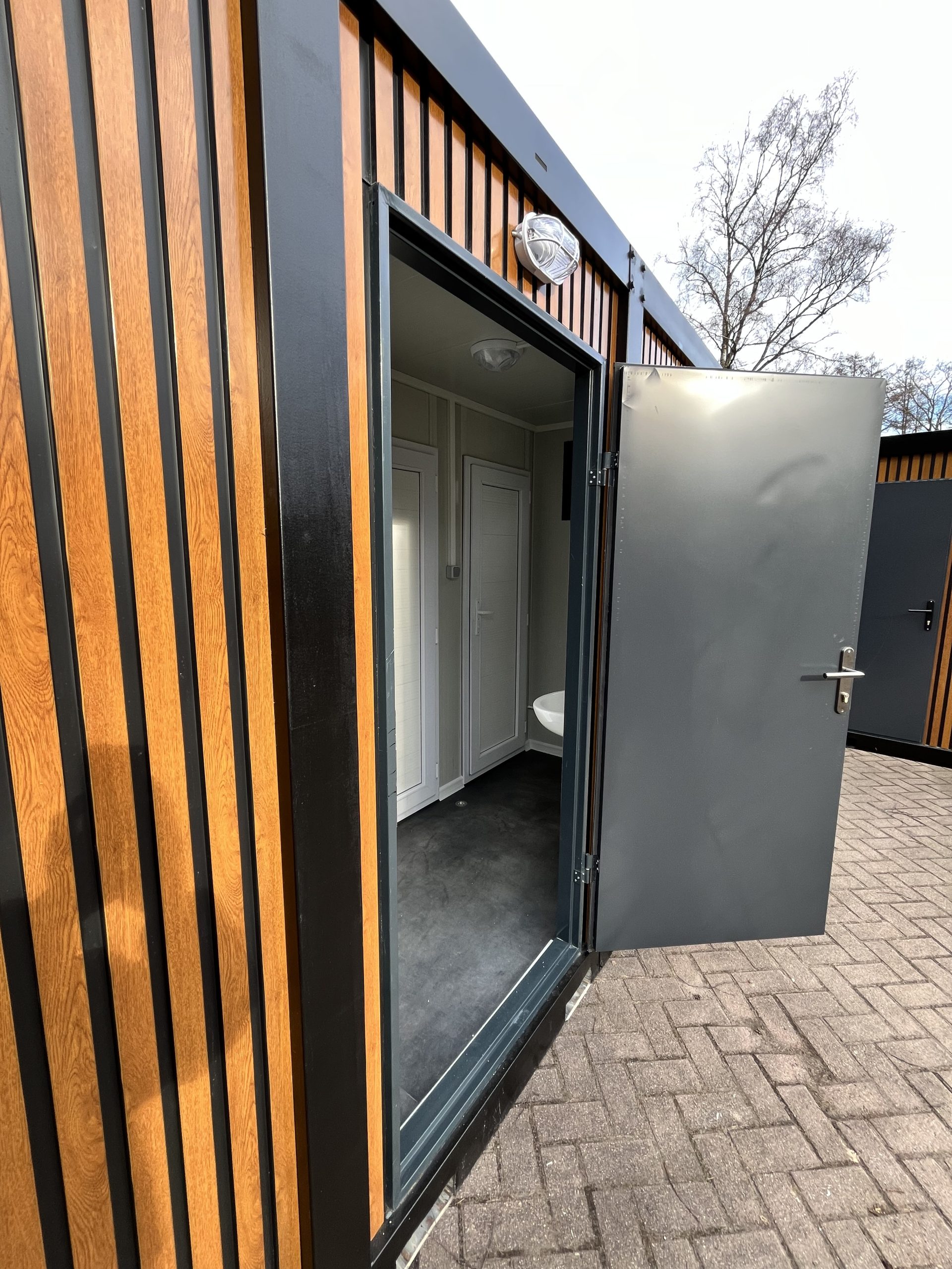 prefab toiletgebouw open deur voorkant