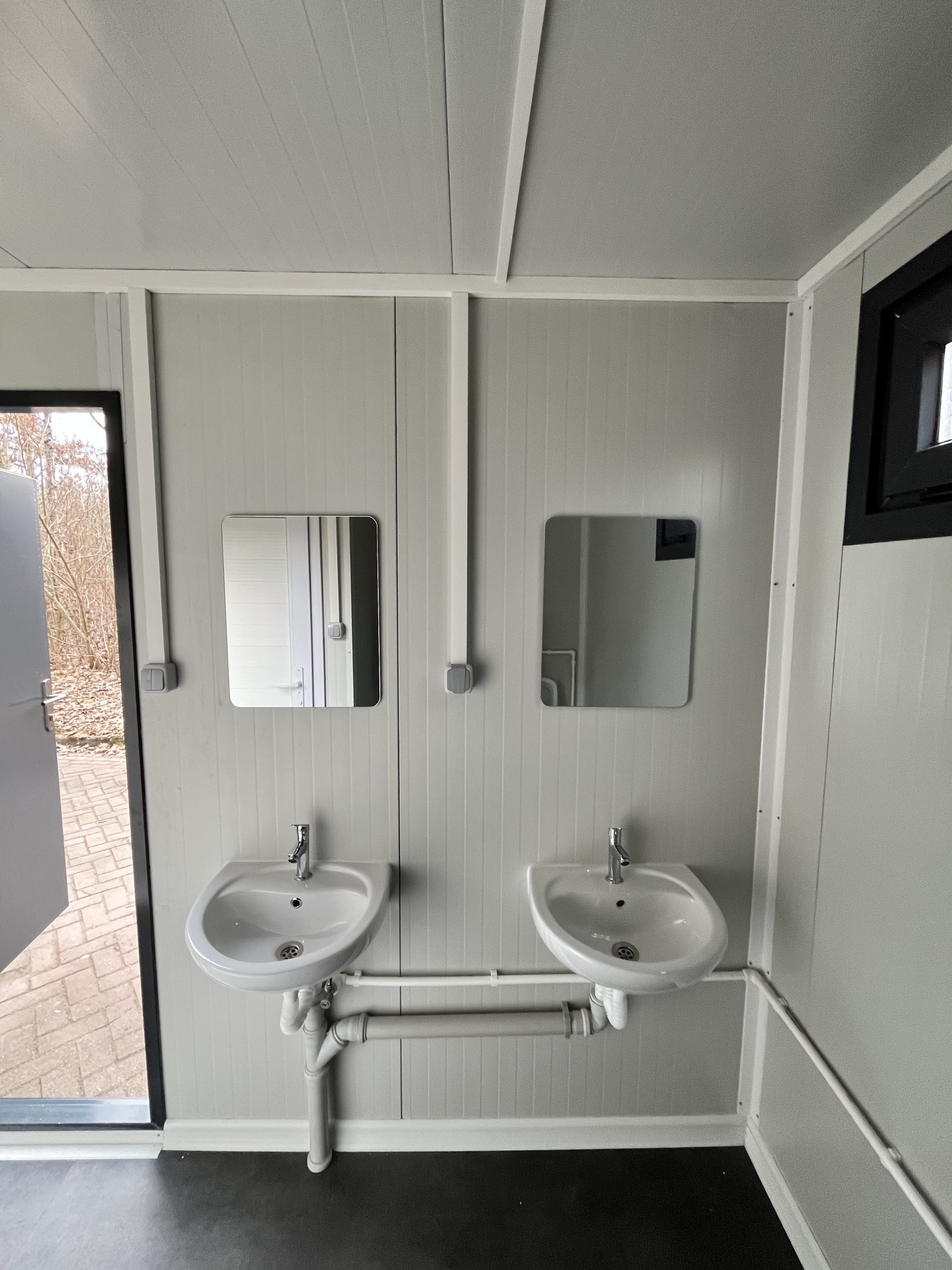prefab toiletgebouw wastafels met spiegels