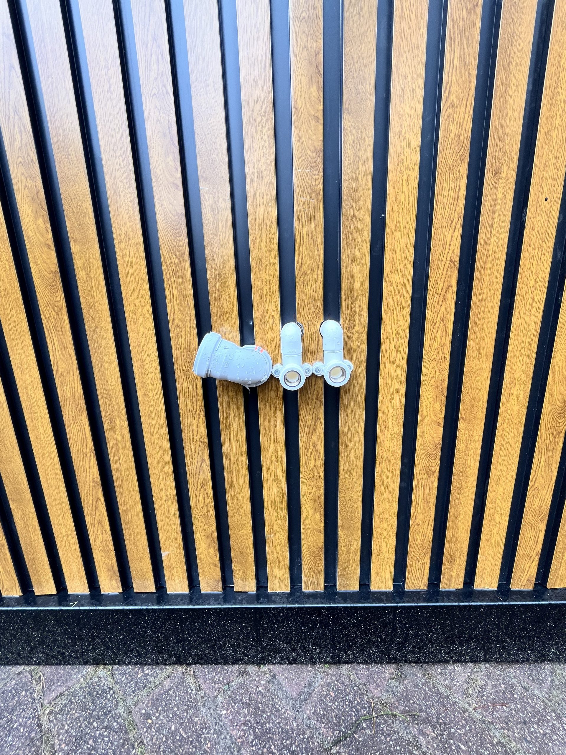 Close-up van zijkant van maatwerk sanitairgebouw met water- en elektra-aansluitingen