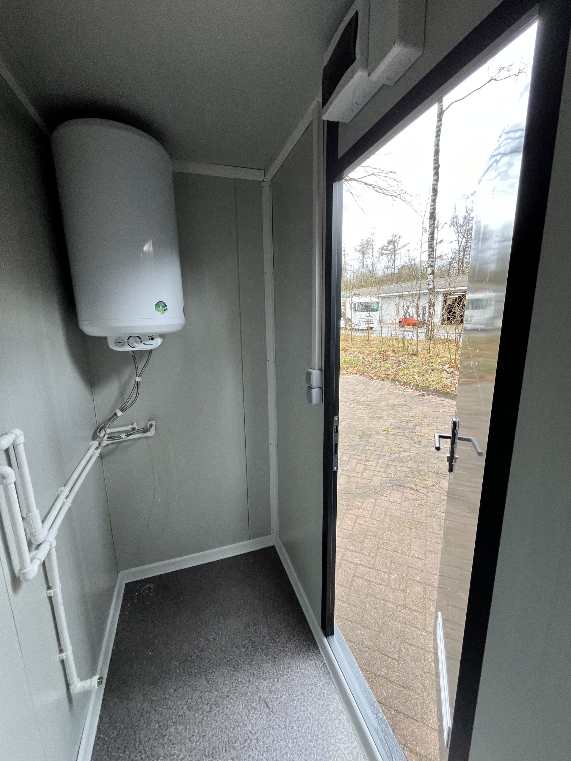 Binnenzijde van technische ruimte in maatwerk sanitairgebouw met installaties en leidingen