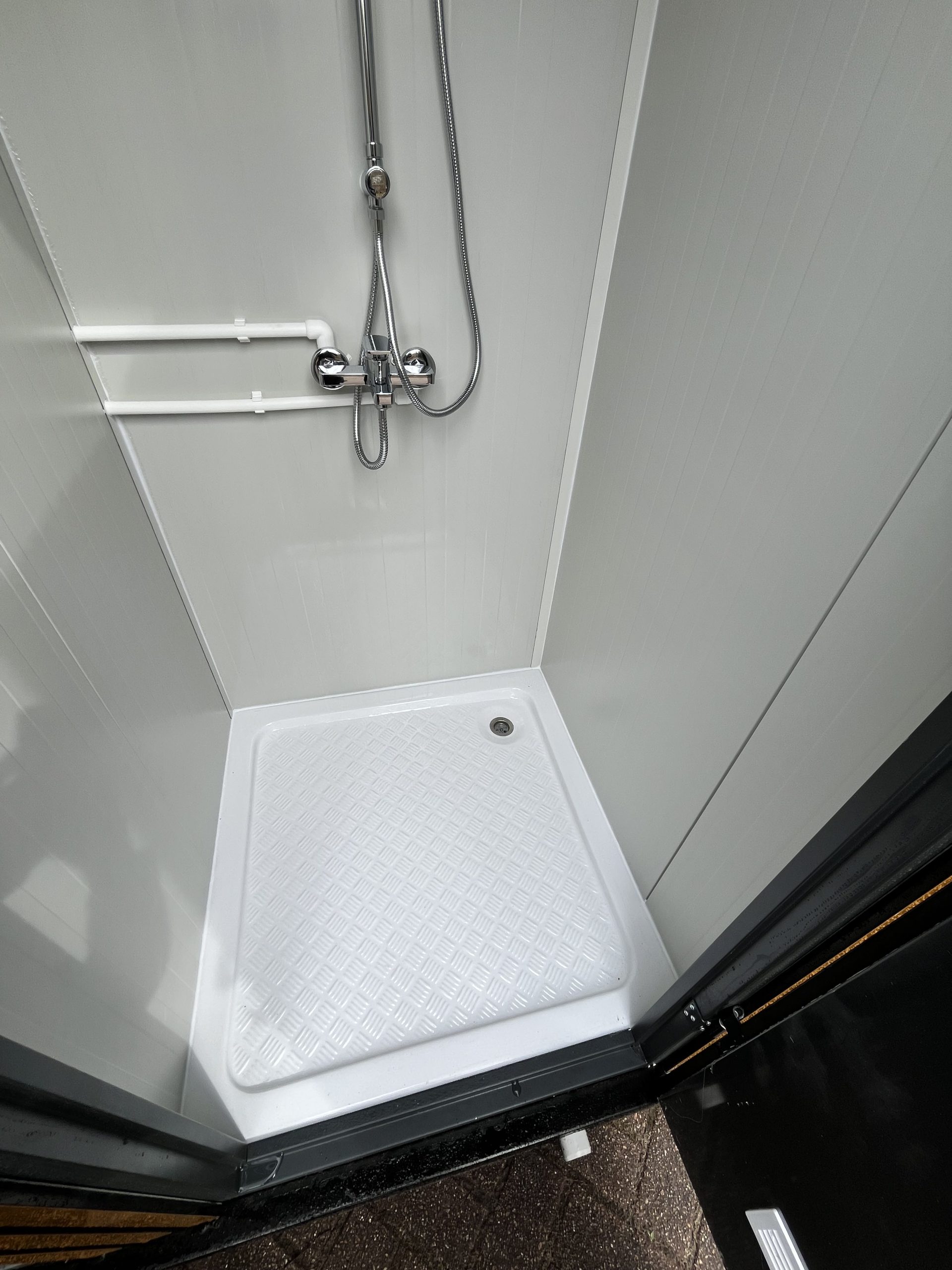 Douchebak in maatwerk sanitairgebouw met stevige afwerking en goede waterafvoer