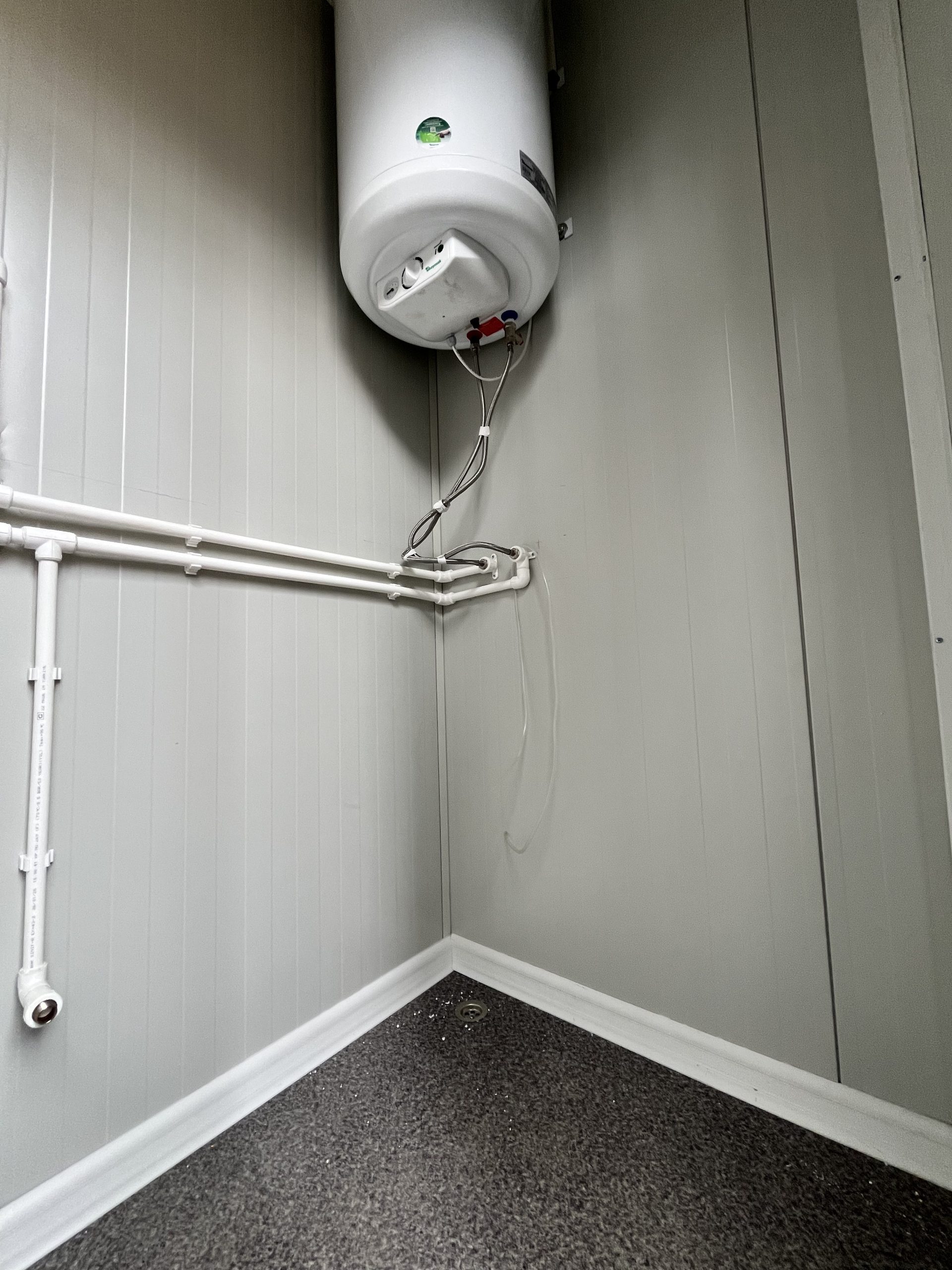 Onderkant van maatwerk sanitairgebouw met zichtbare boiler en installaties