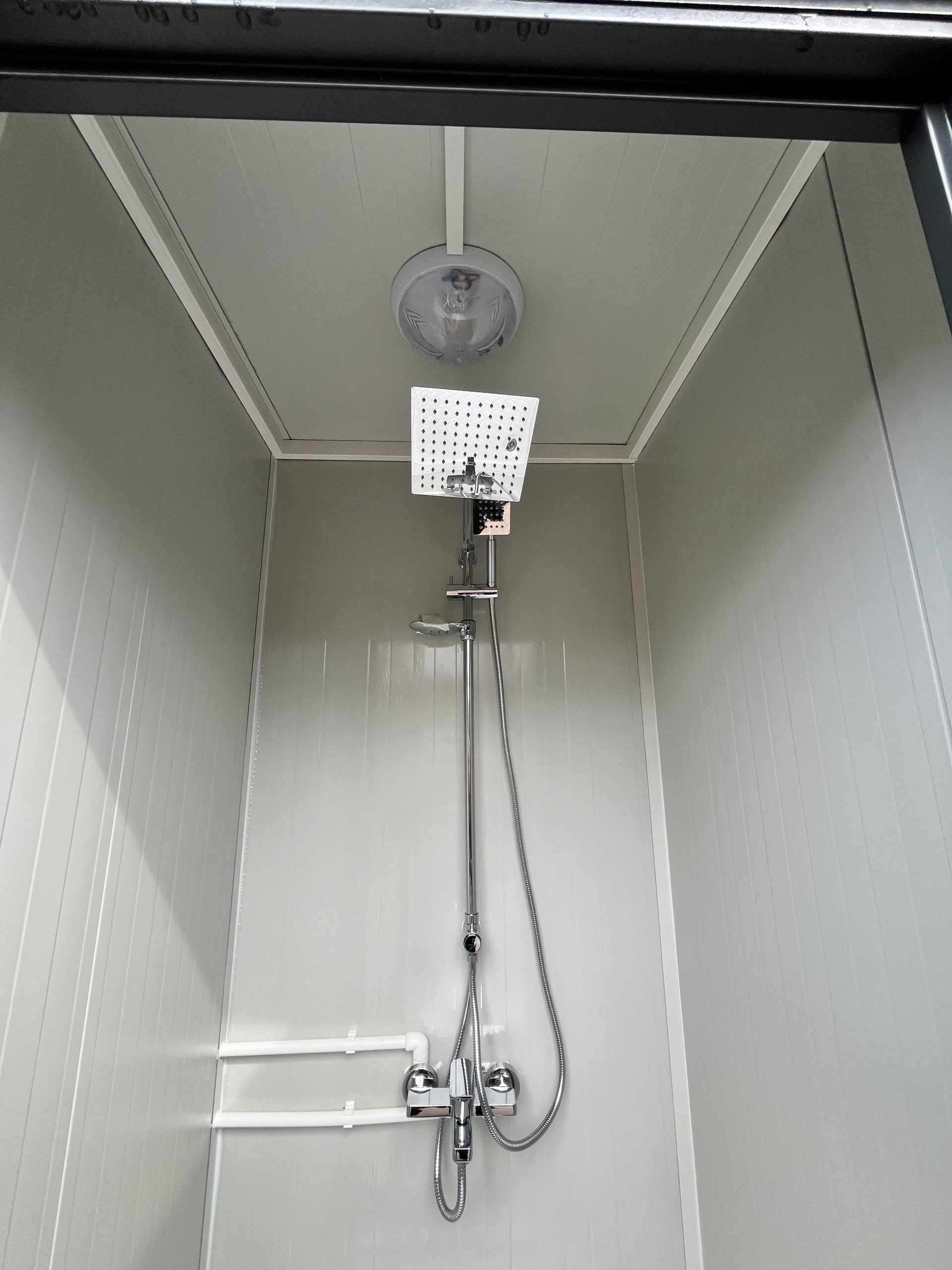 Regendouche in maatwerk sanitairgebouw met luxe uitstraling en gelijkmatige waterverdeling