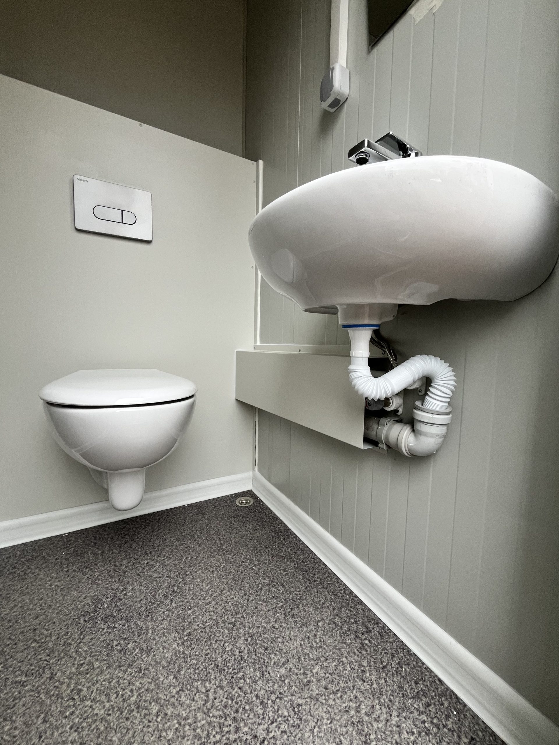 Weggewerkt leidingwerk in toiletruimte van maatwerk sanitairgebouw voor een strakke en nette afwerking