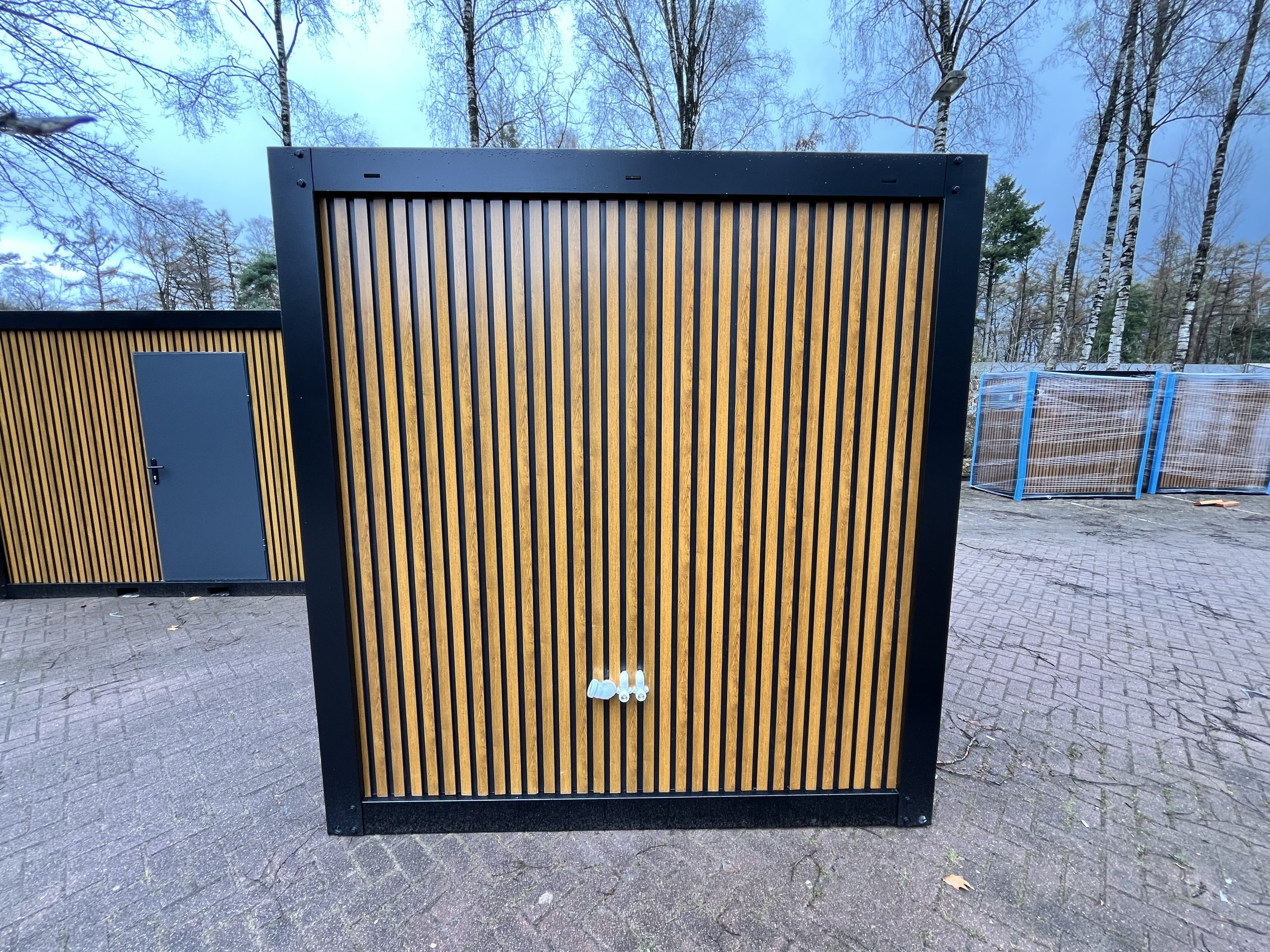 Zijkant van maatwerk sanitairgebouw met zichtbare water- en elektra-aansluitingen