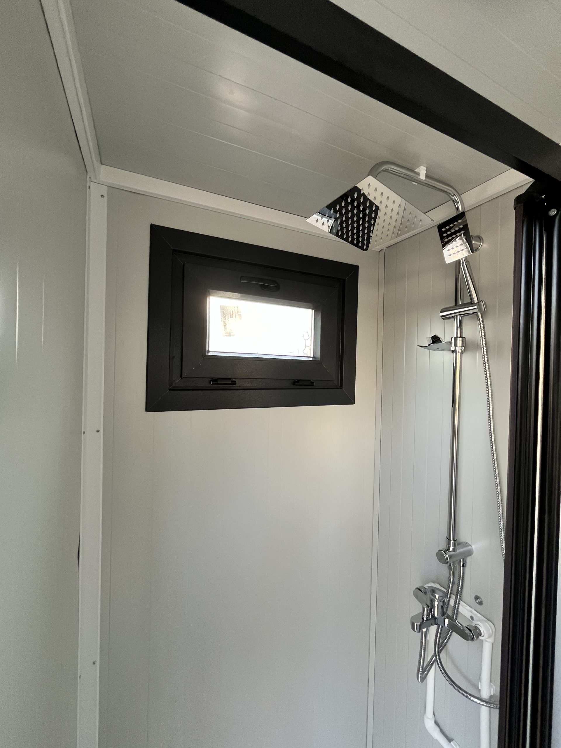 Close-up van doucheruimte in mobiele badkamer unit met 4 ruimtes