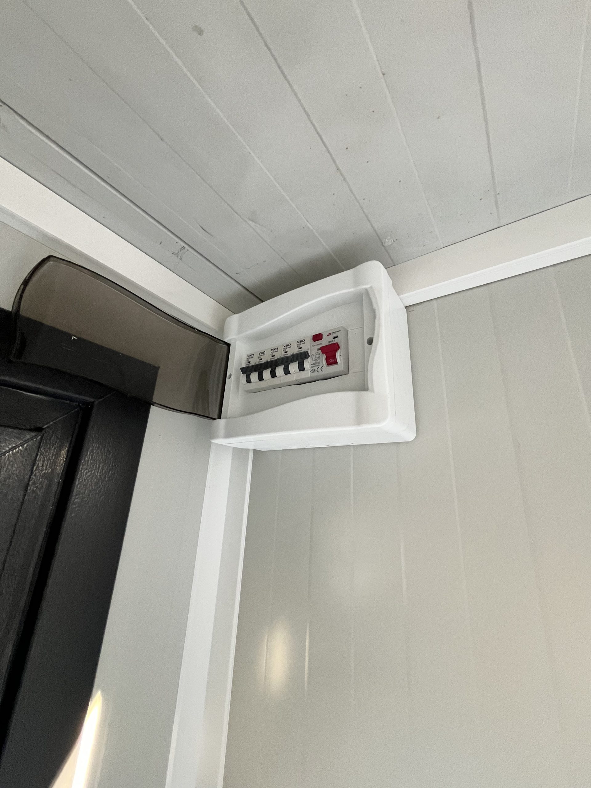 Geopende groepenkast in mobiele badkamer unit met 4 ruimtes