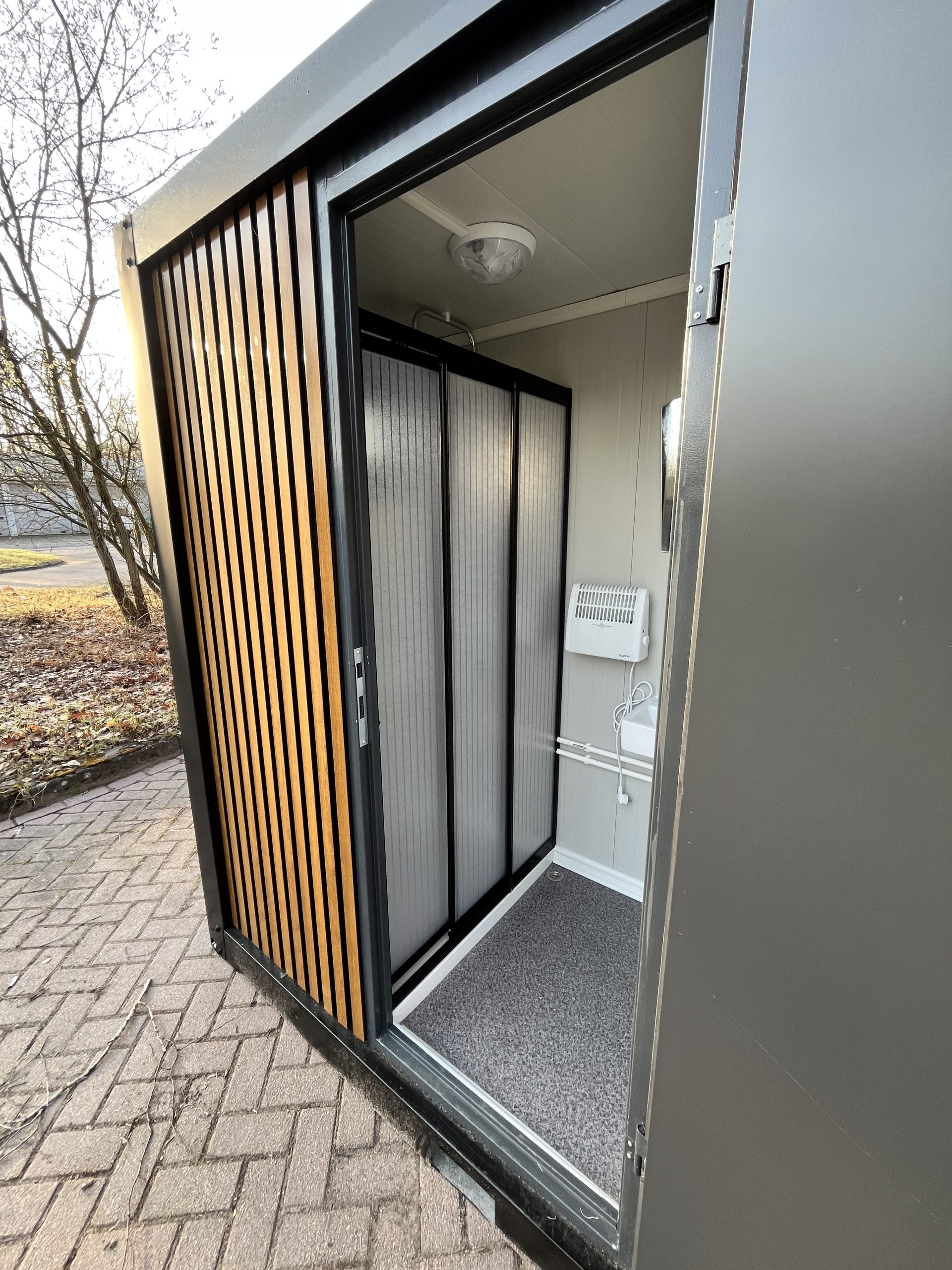 Inkijk in doucheruimte van mobiele badkamer unit met 4 ruimtes