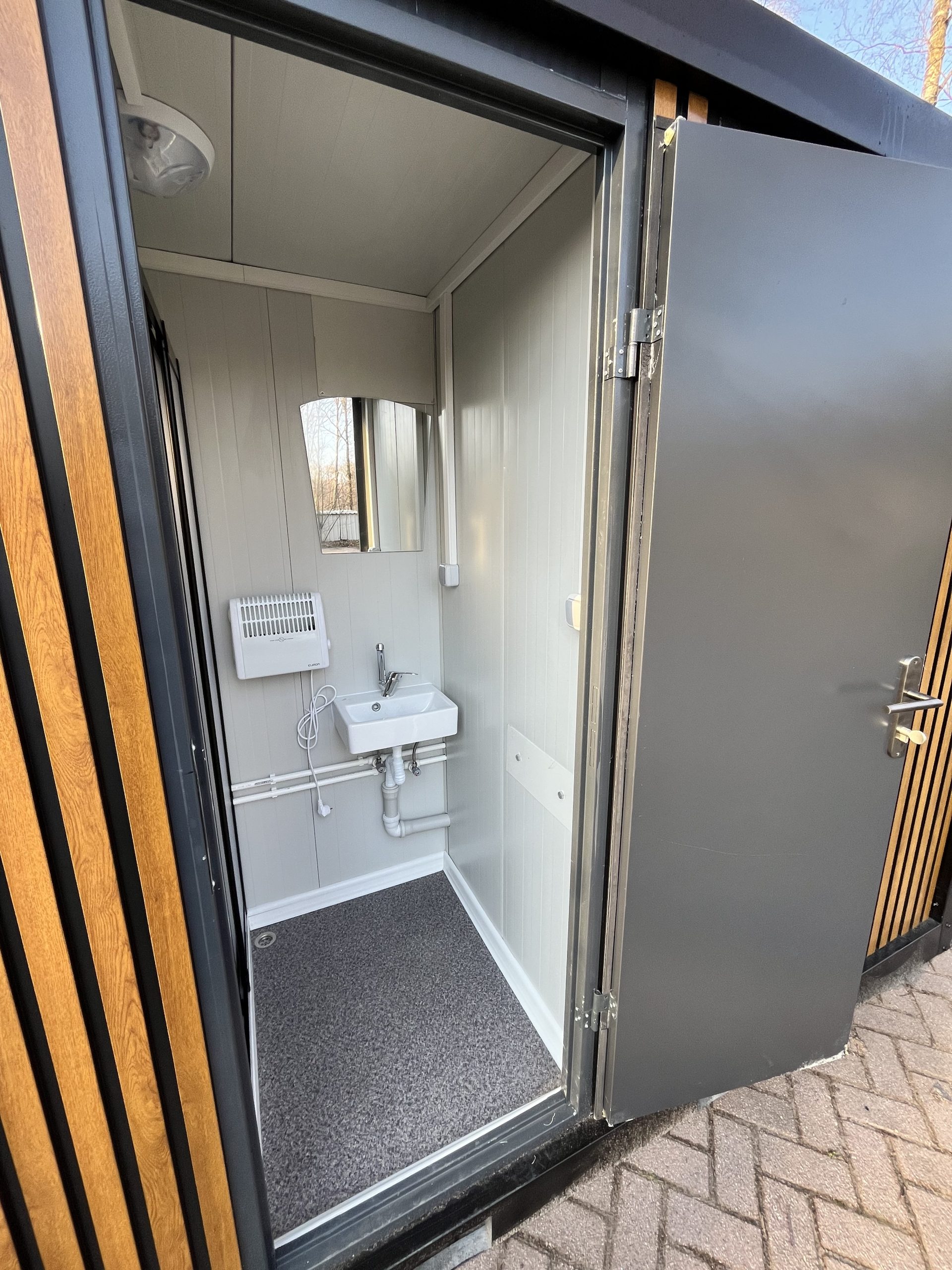 Inkijk in doucheruimte van mobiele badkamer unit met 4 ruimtes