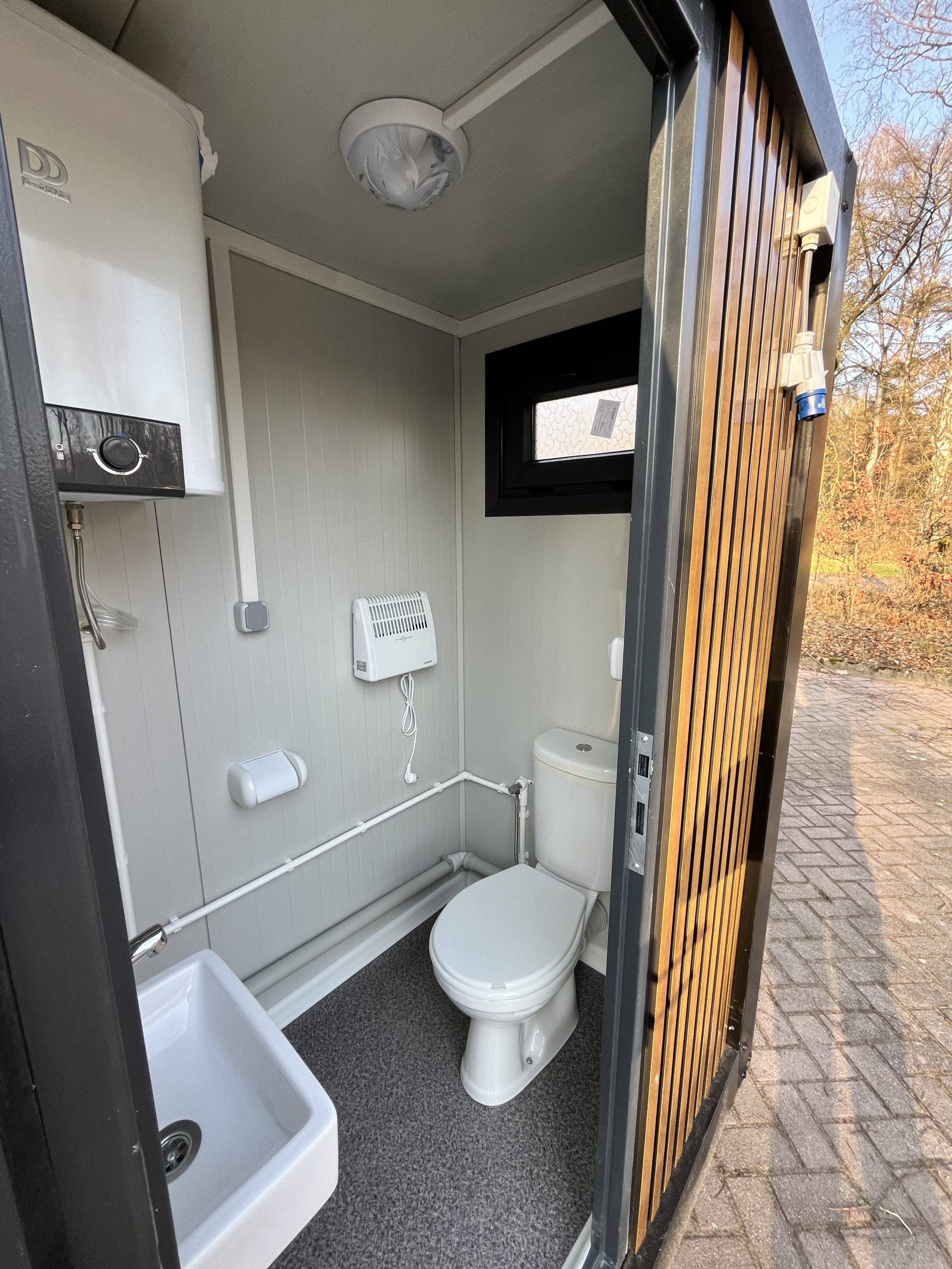 Inkijk in toiletruimte van mobiele badkamer unit met 4 ruimtes