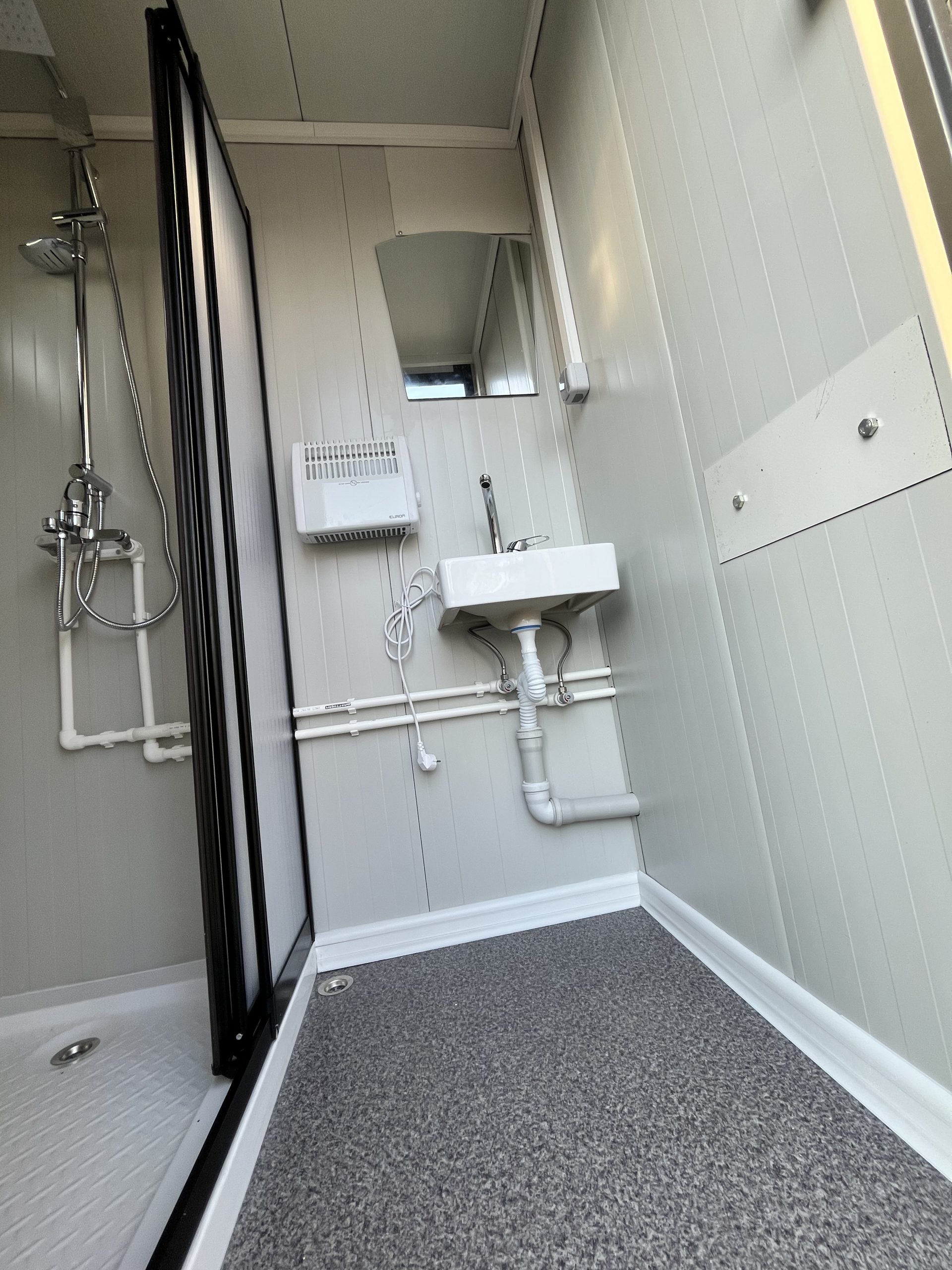 Leidingwerk in doucheruimte van mobiele badkamer unit met 4 ruimtes