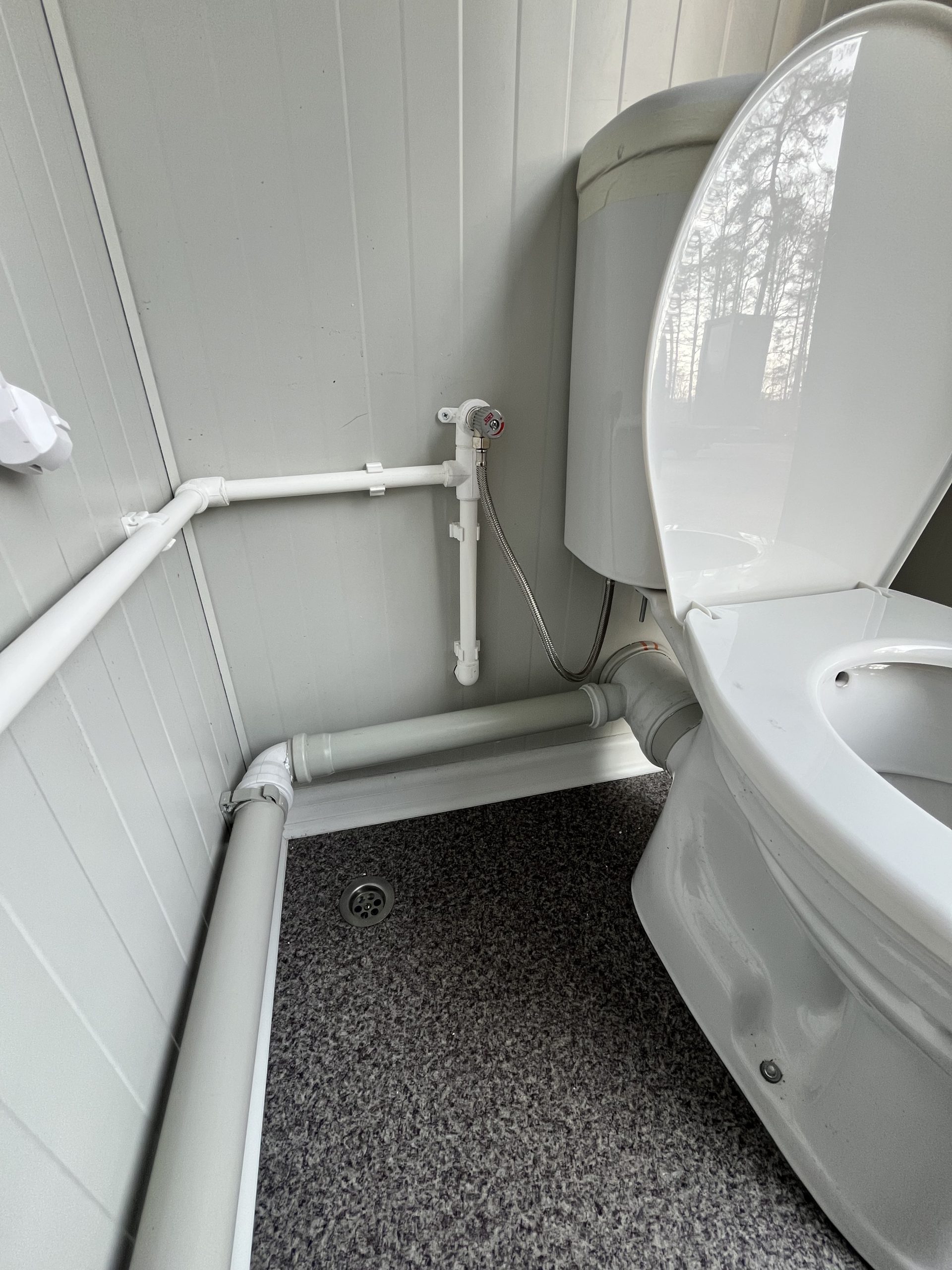 Leidingwerk bij toiletpot in mobiele badkamer unit met 4 ruimtes