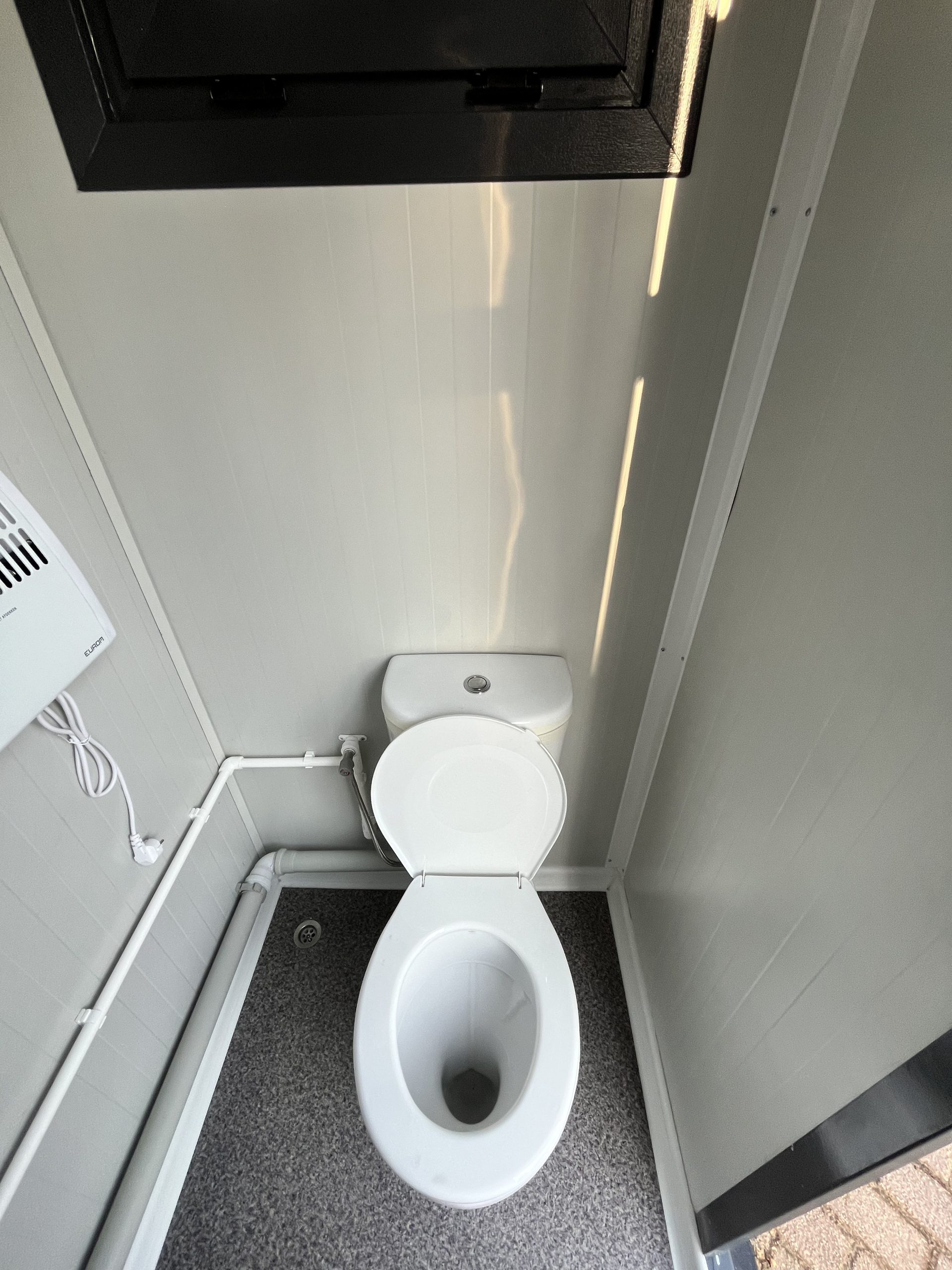 Geopende toiletpot in mobiele badkamer unit met 4 ruimtes