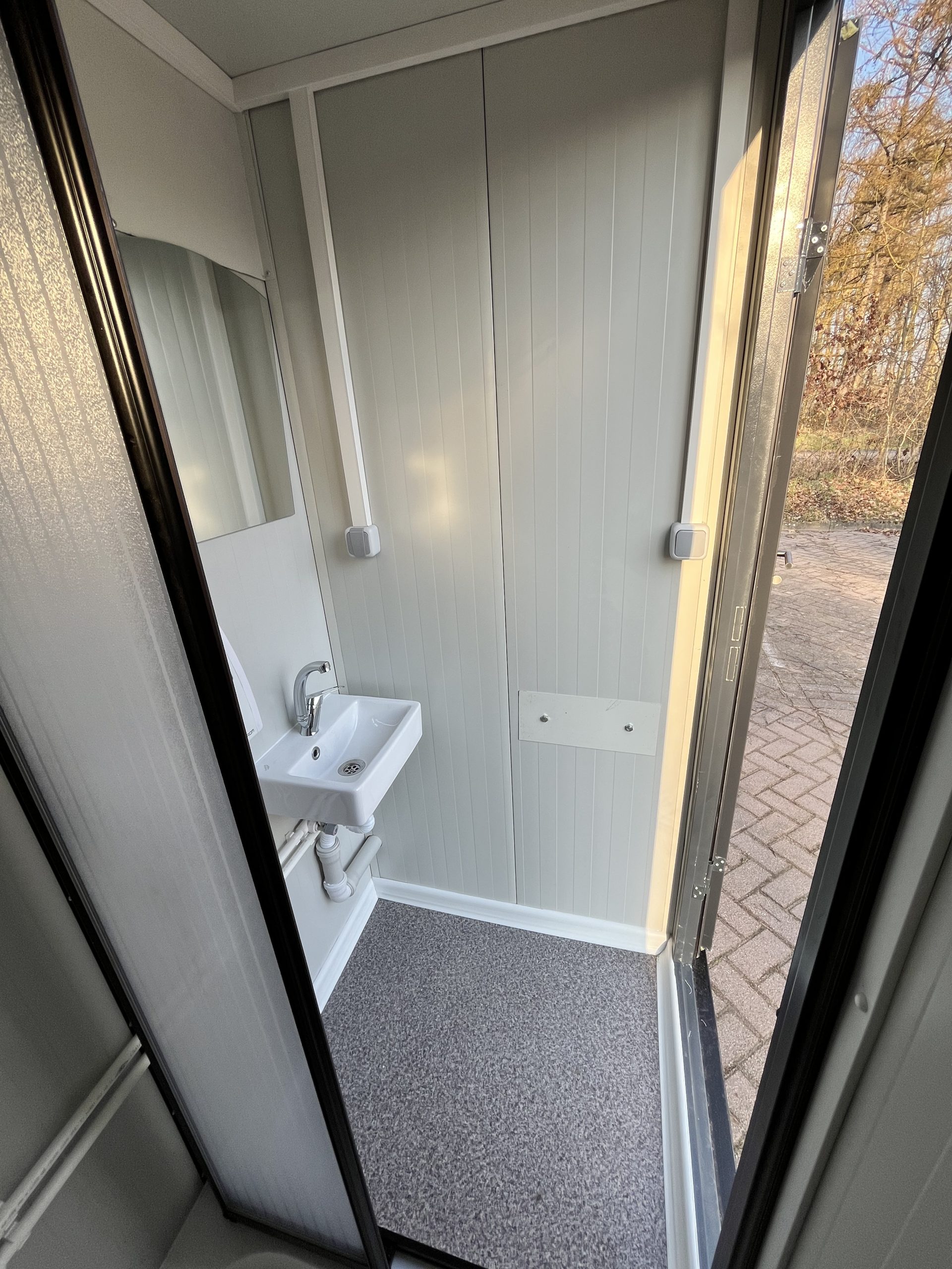 Wasbak met kraan en spiegel in mobiele badkamer unit met 4 ruimtes