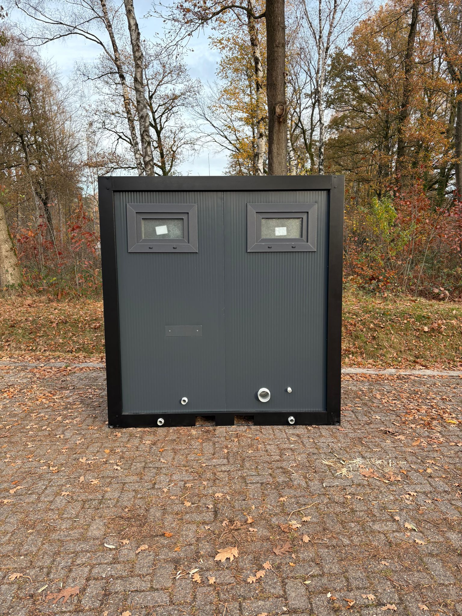 Achterzijde van de buitenzijde van een toilet- en urinoirunit.