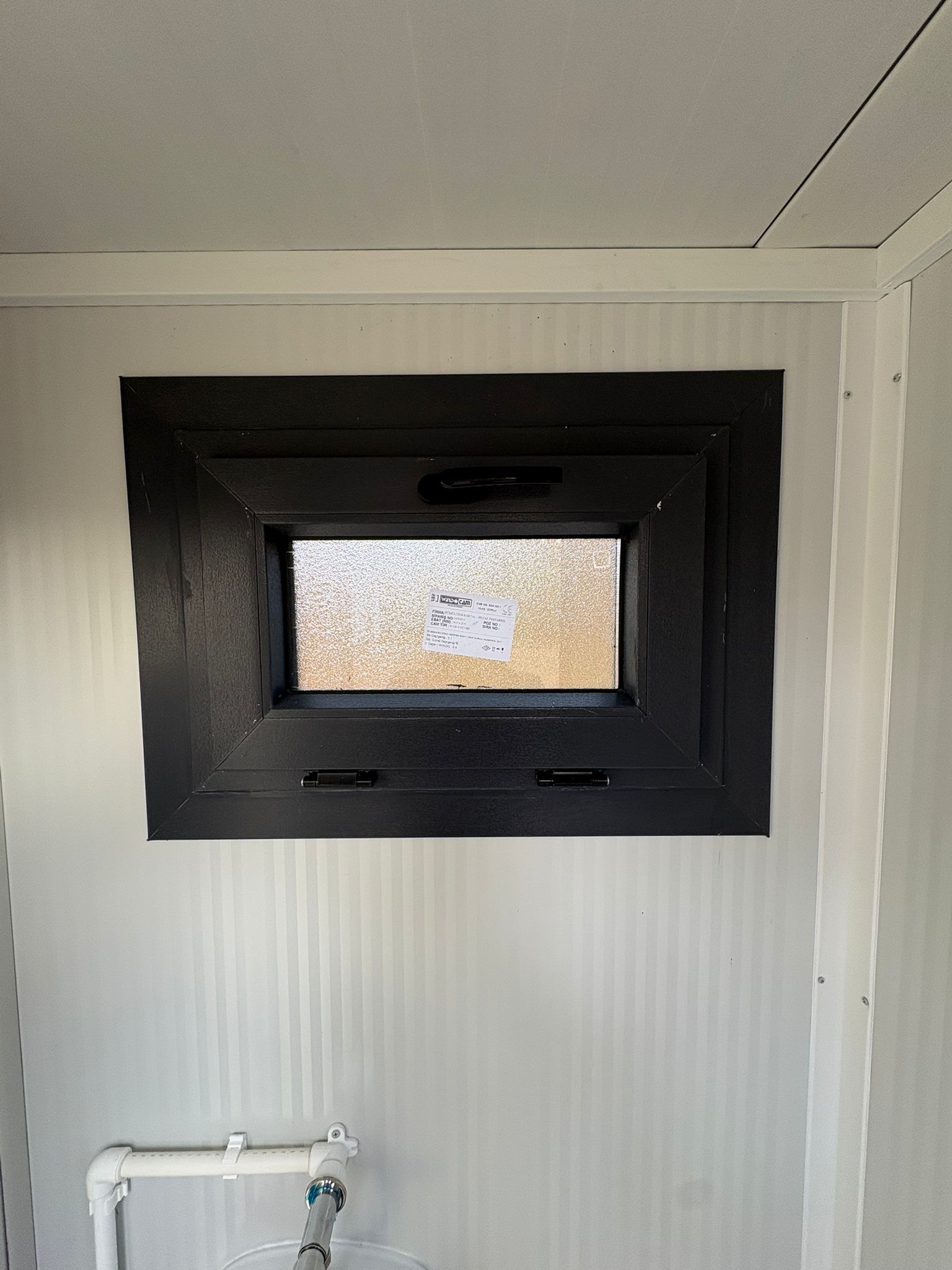 Dicht draaikiepraam aan de urinoir­kant van een toilet- en urinoirunit.