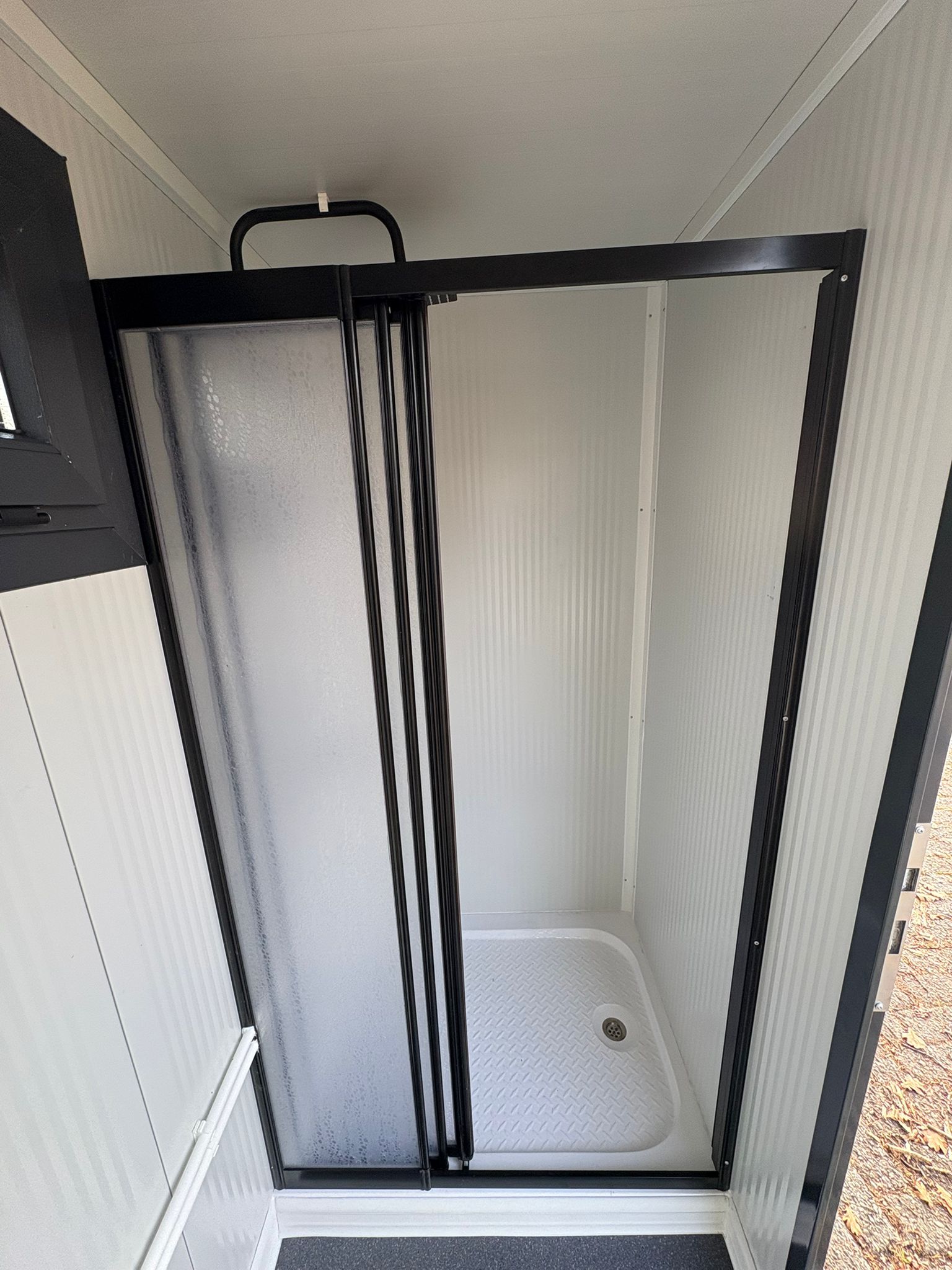 Glazen douchewand van een gesloten doucheunit met omkleedruimte.