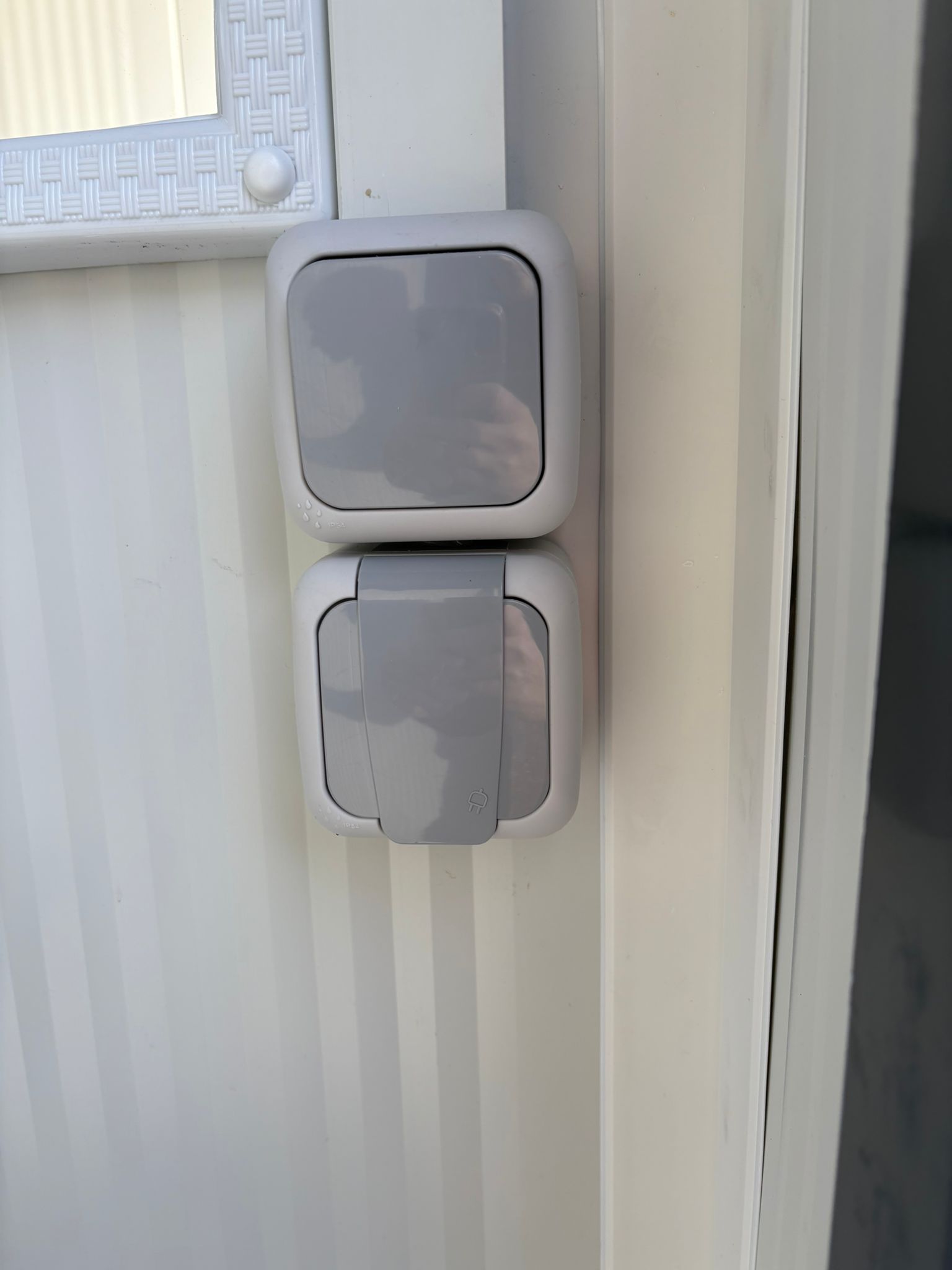 Lichtschakelaar en wandcontactdoos van een toilet- en urinoirunit.