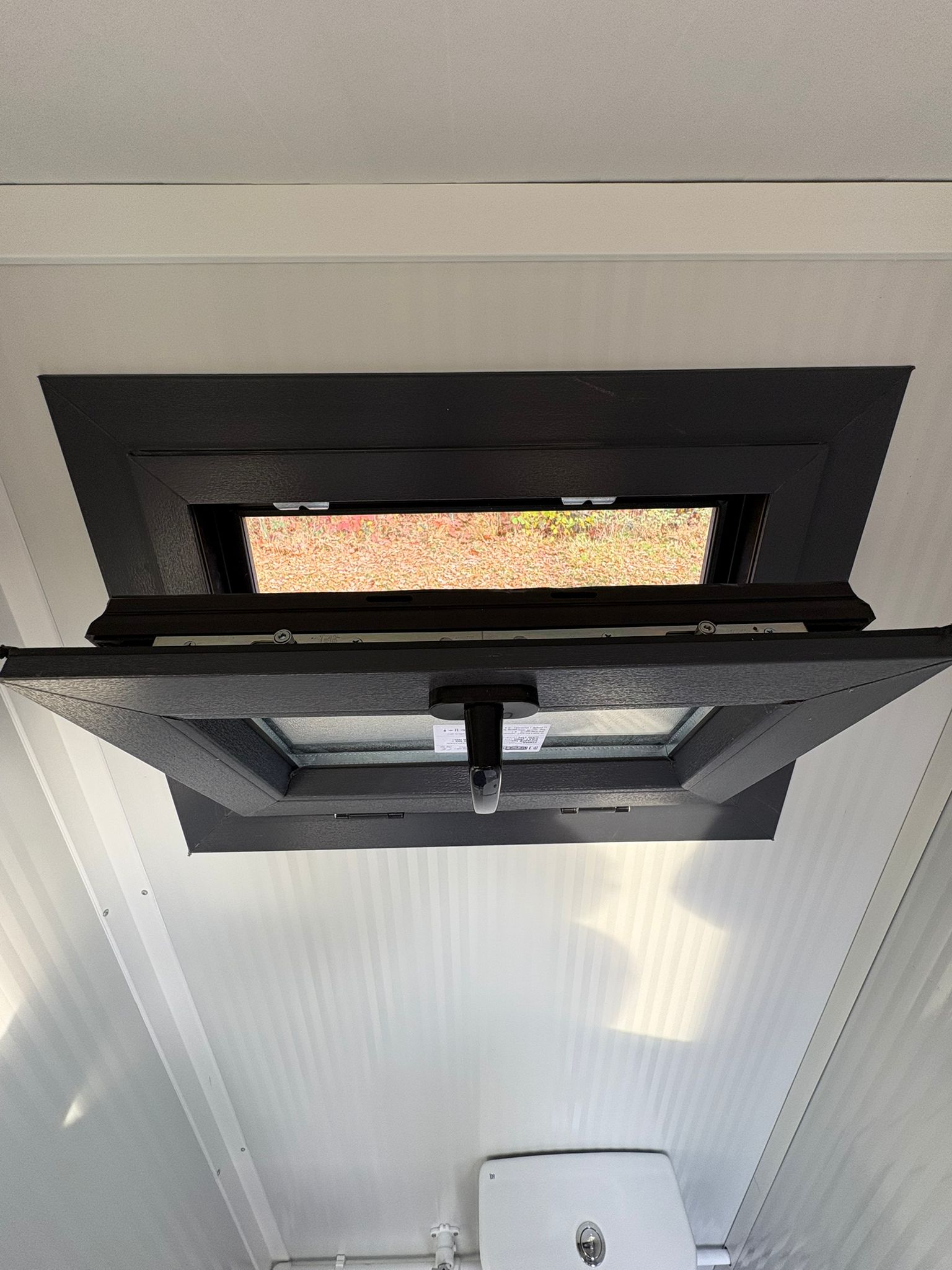 Openstaand draaikiepraam van een toilet- en urinoirunit.