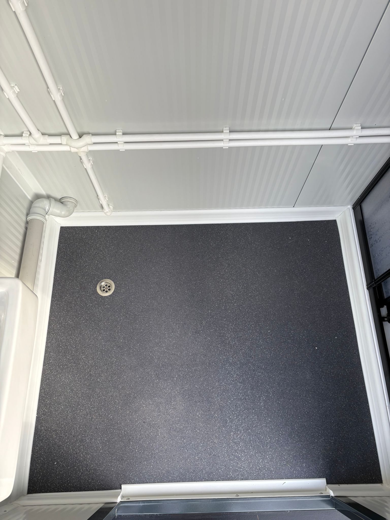 Vloer van een doucheunit met omkleedruimte.