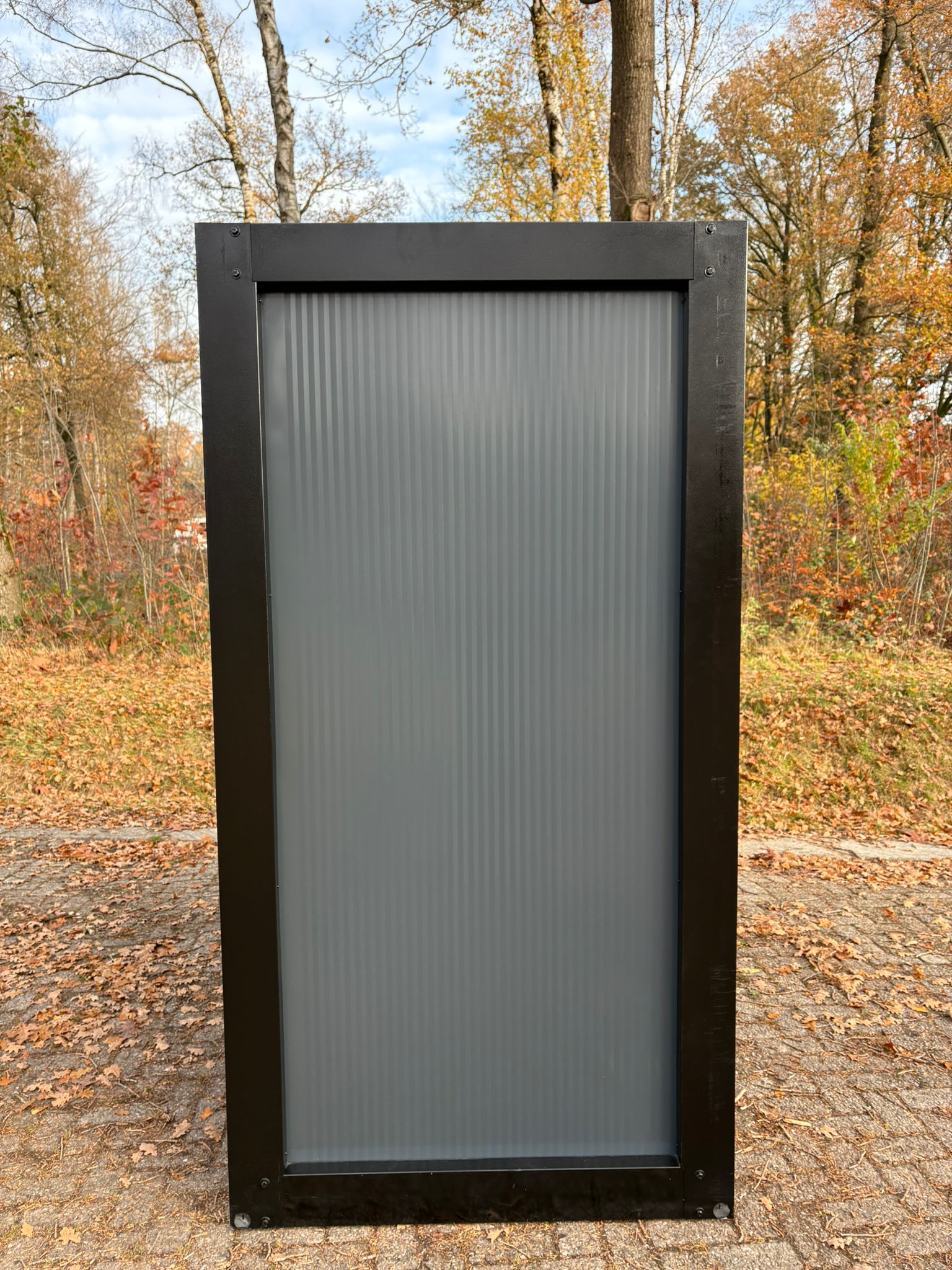 Zijkant van een gladde doucheunit met omkleedruimte.