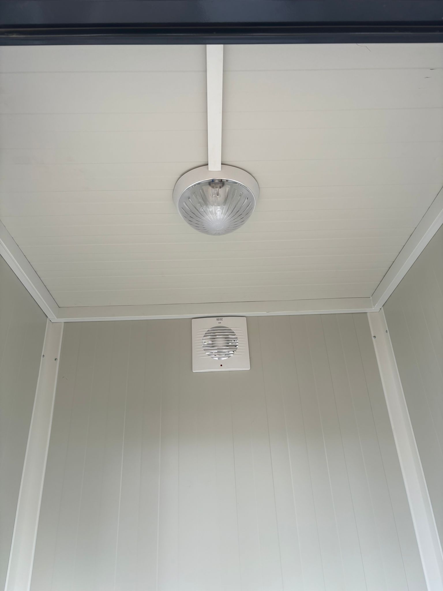Binnenzijde van een duo mobiele toiletunit met verlichting en ventilatie zichtbaar