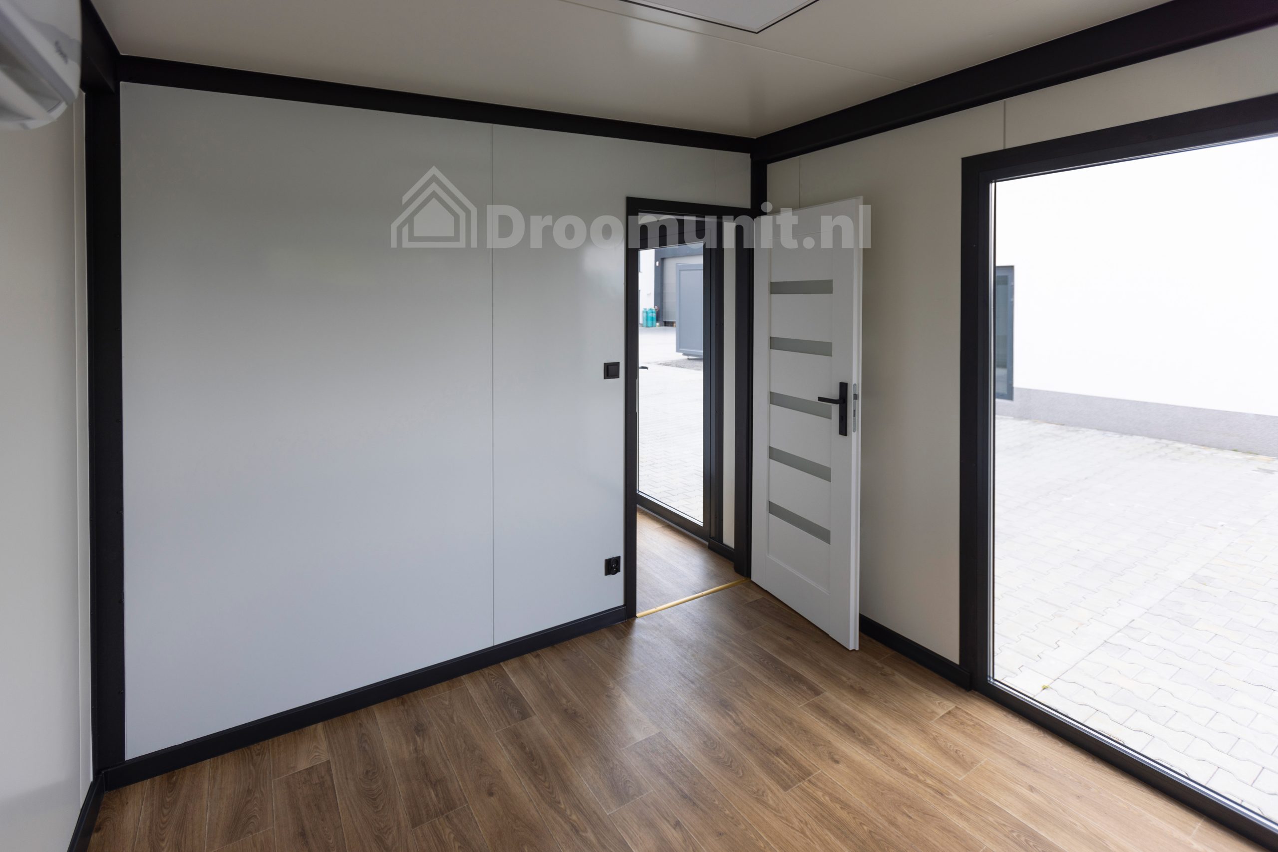 luxe_mobiele_prefab_woonunit_emmy_1_slaapkamer_afmeting_1300x300_leefruimte_met_kozijn_en_deur_naar_slaapkamer