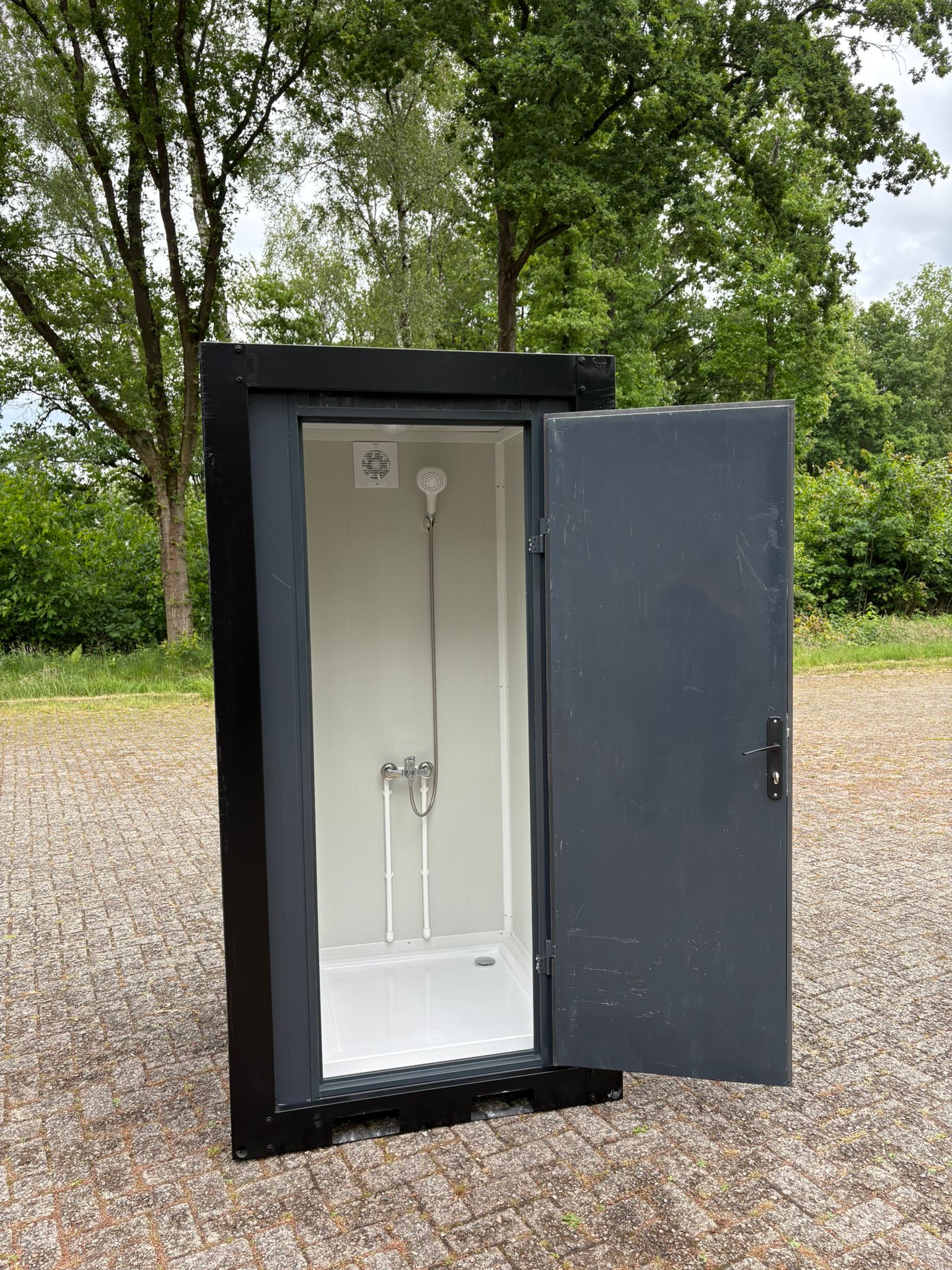 mobiele nooddouche unit buiten met geopende deur