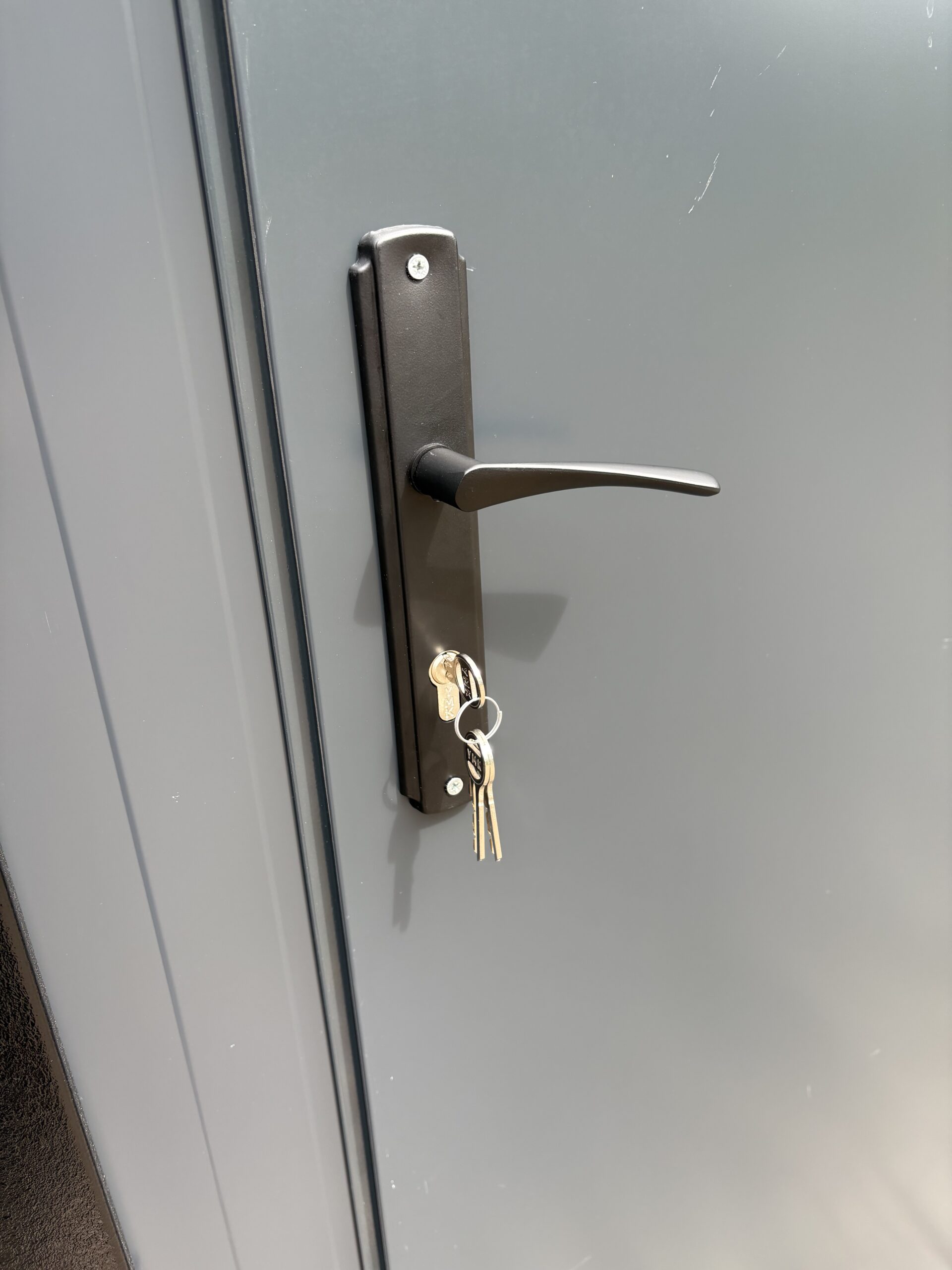 Detail van een deurklink met slot op een mobiele douchecabine unit
