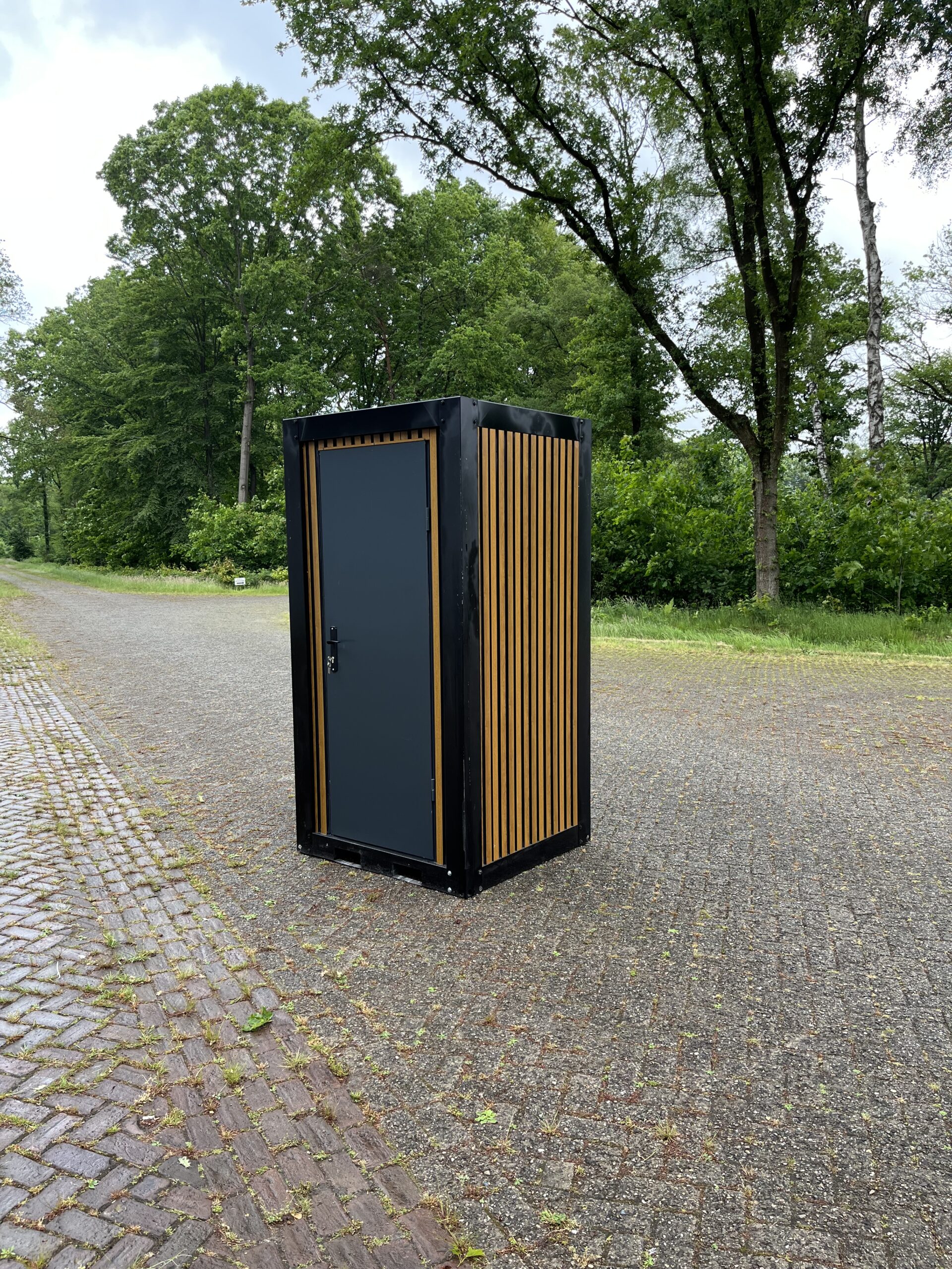 Voorzijde van een mobiele douchecabine unit met pvc houtlook afwerking