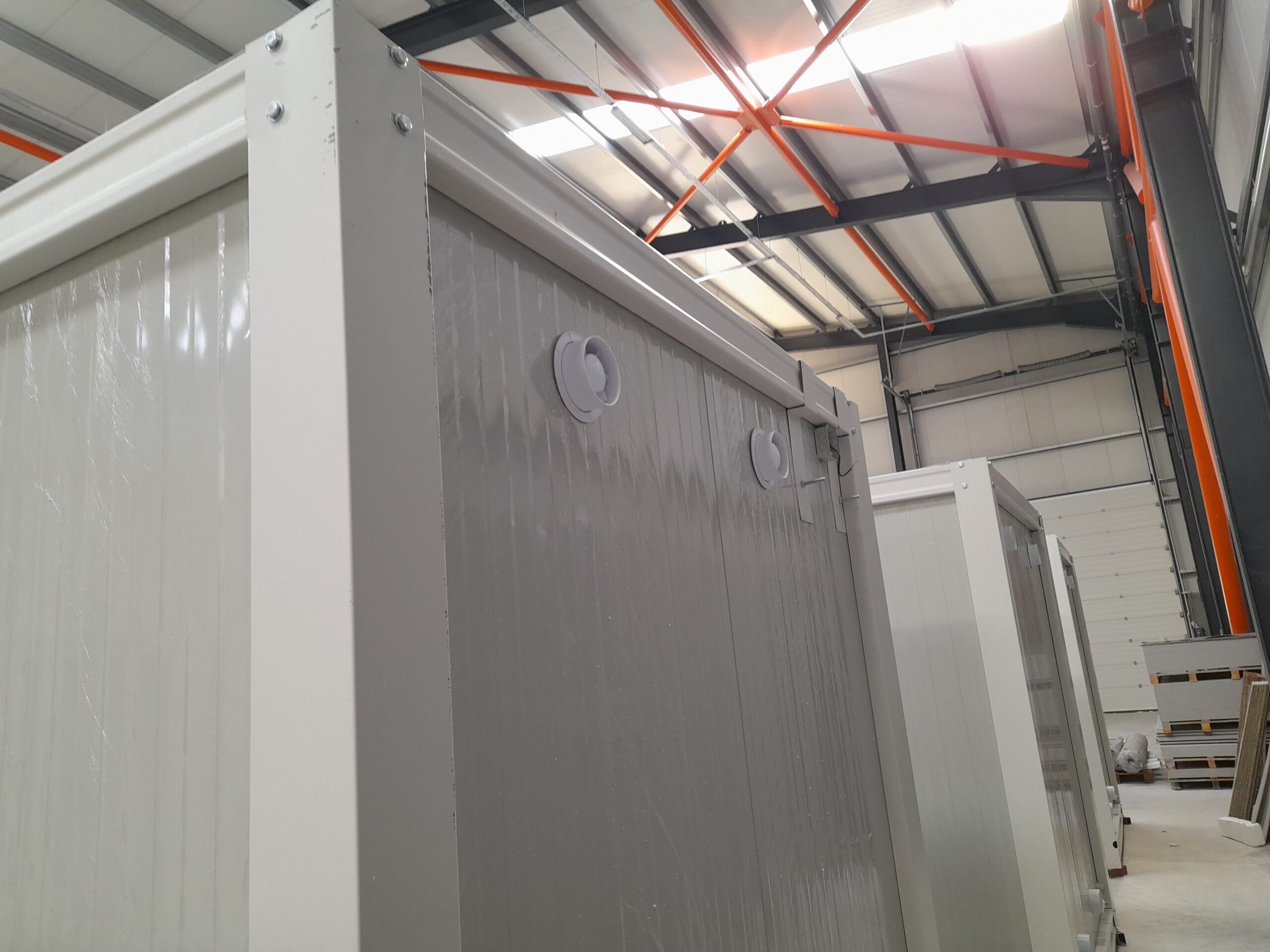 Achterzijde van een mobiele wc- en douche unit met elektrische ventilatie tijdens de constructie