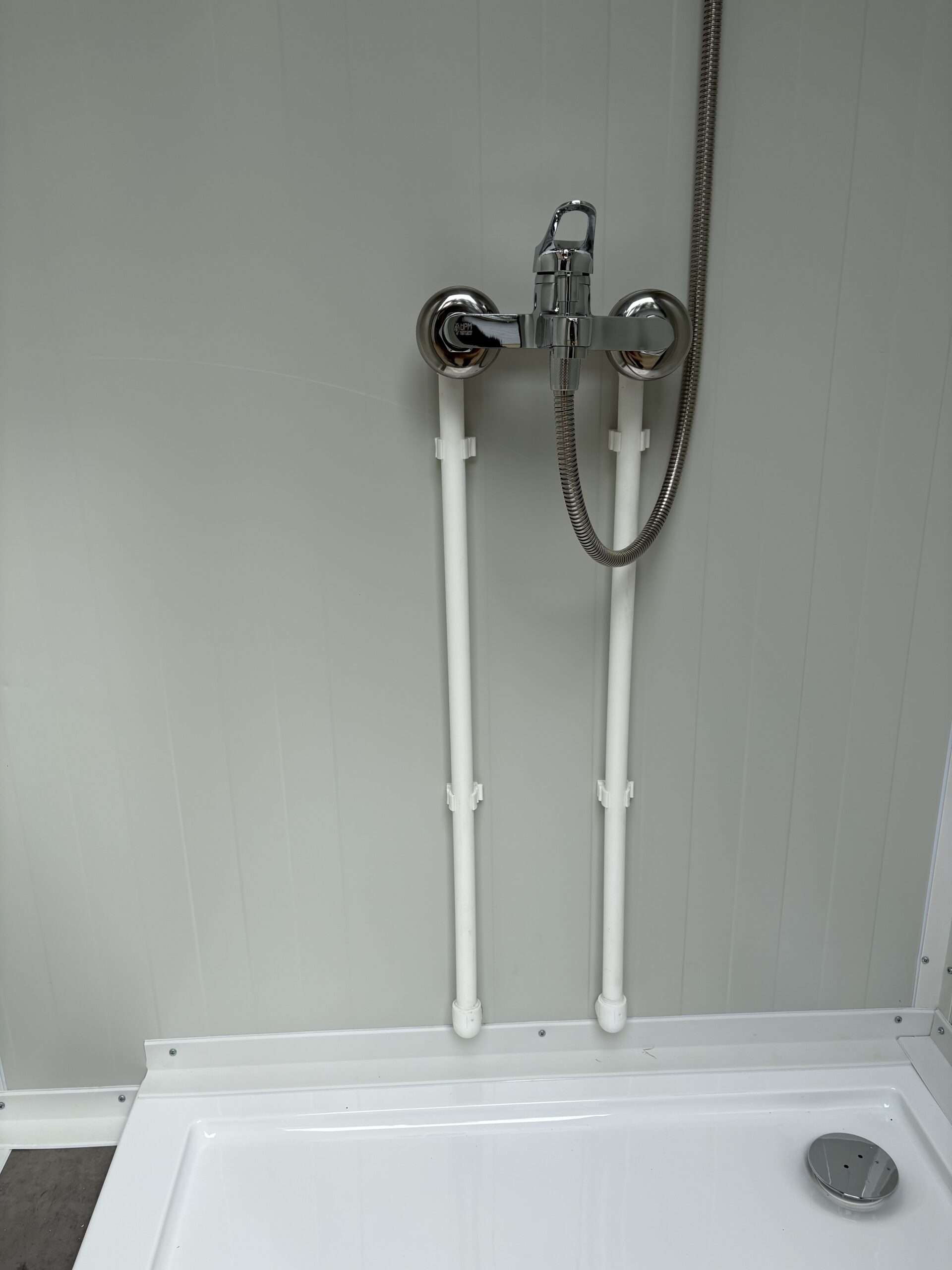 Detail van de mengkraan in de douchecabine van een mobiele wc- en douche unit