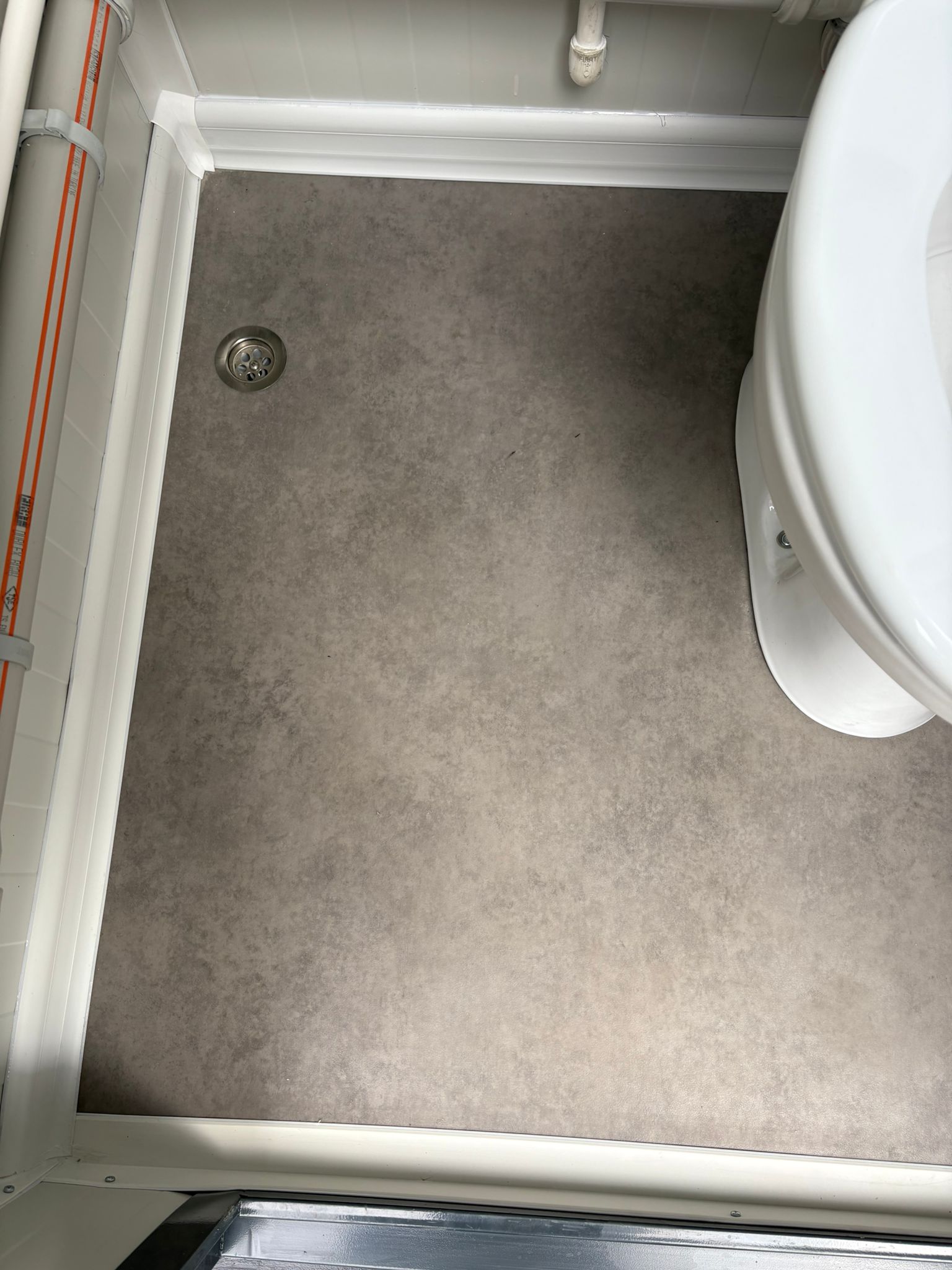 Binnenzijde van de toiletcabine in een mobiele wc- en douche unit met toiletpot en vloerput